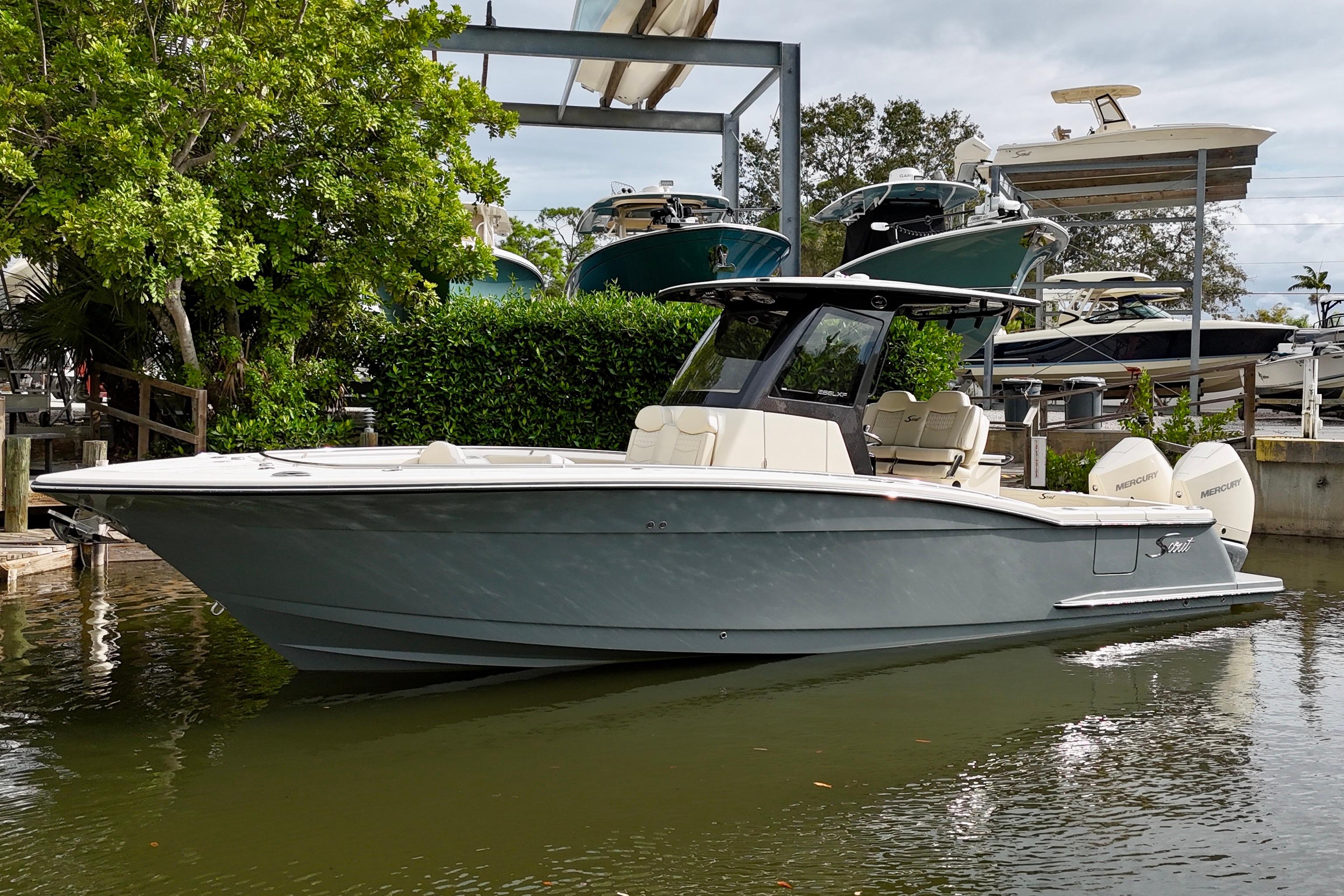 2026 Scout 288 LXF boat docked, featuring sleek design and dual outboard engines.