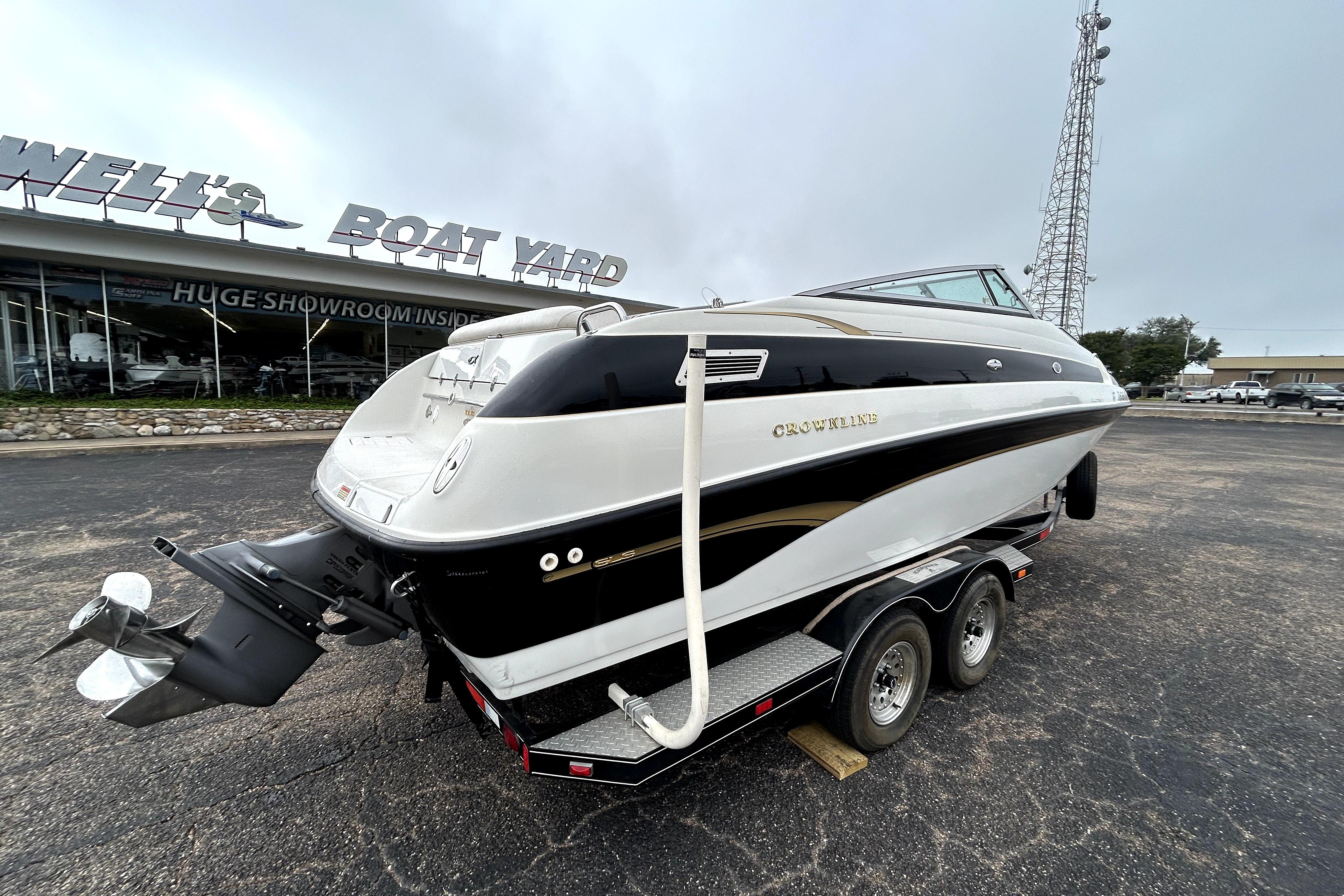 2001 Crownline 239 DB boat on trailer at dealership, rear view.