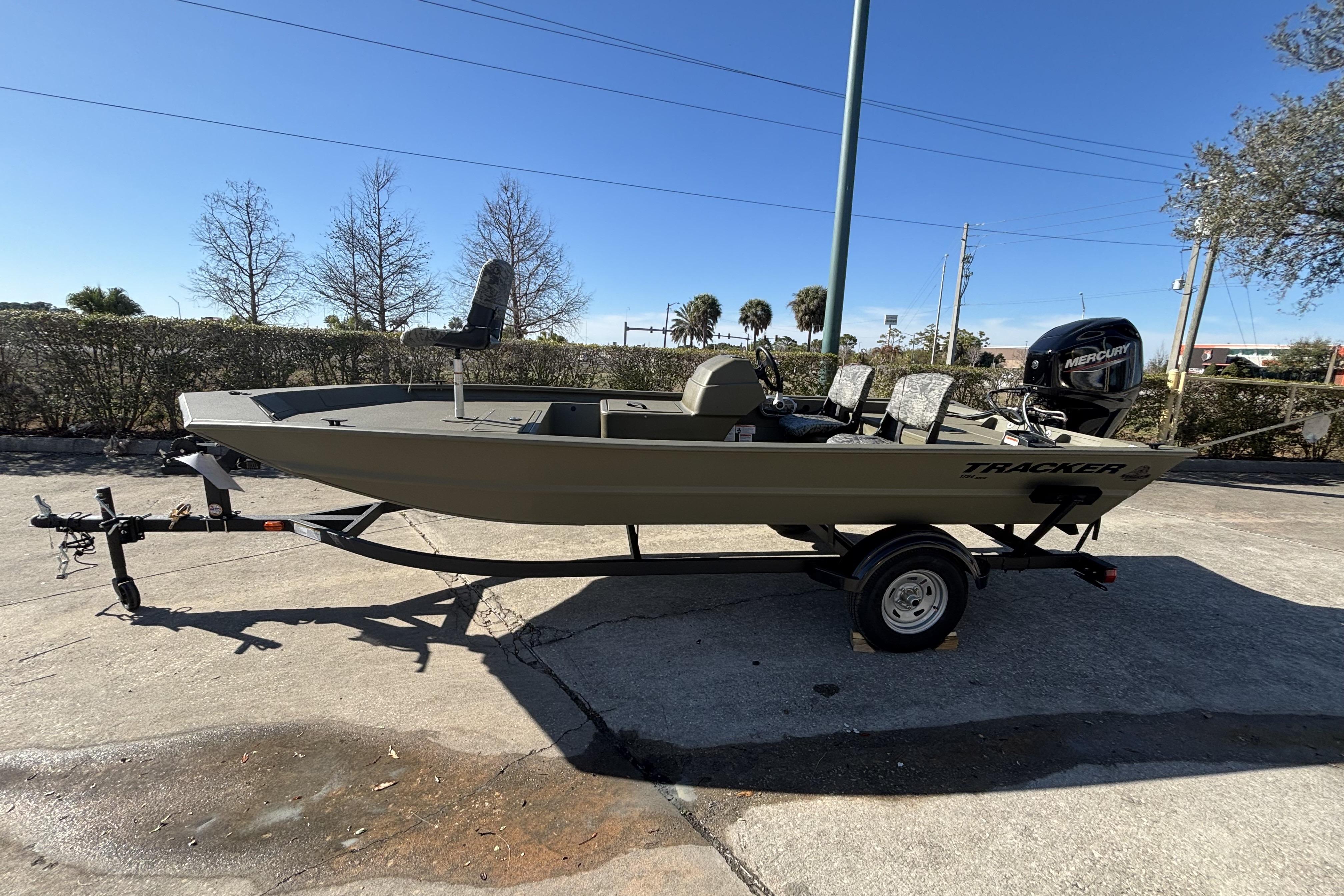 2026 Tracker Grizzly 1754 SC boat on trailer, parked outdoors under clear sky.