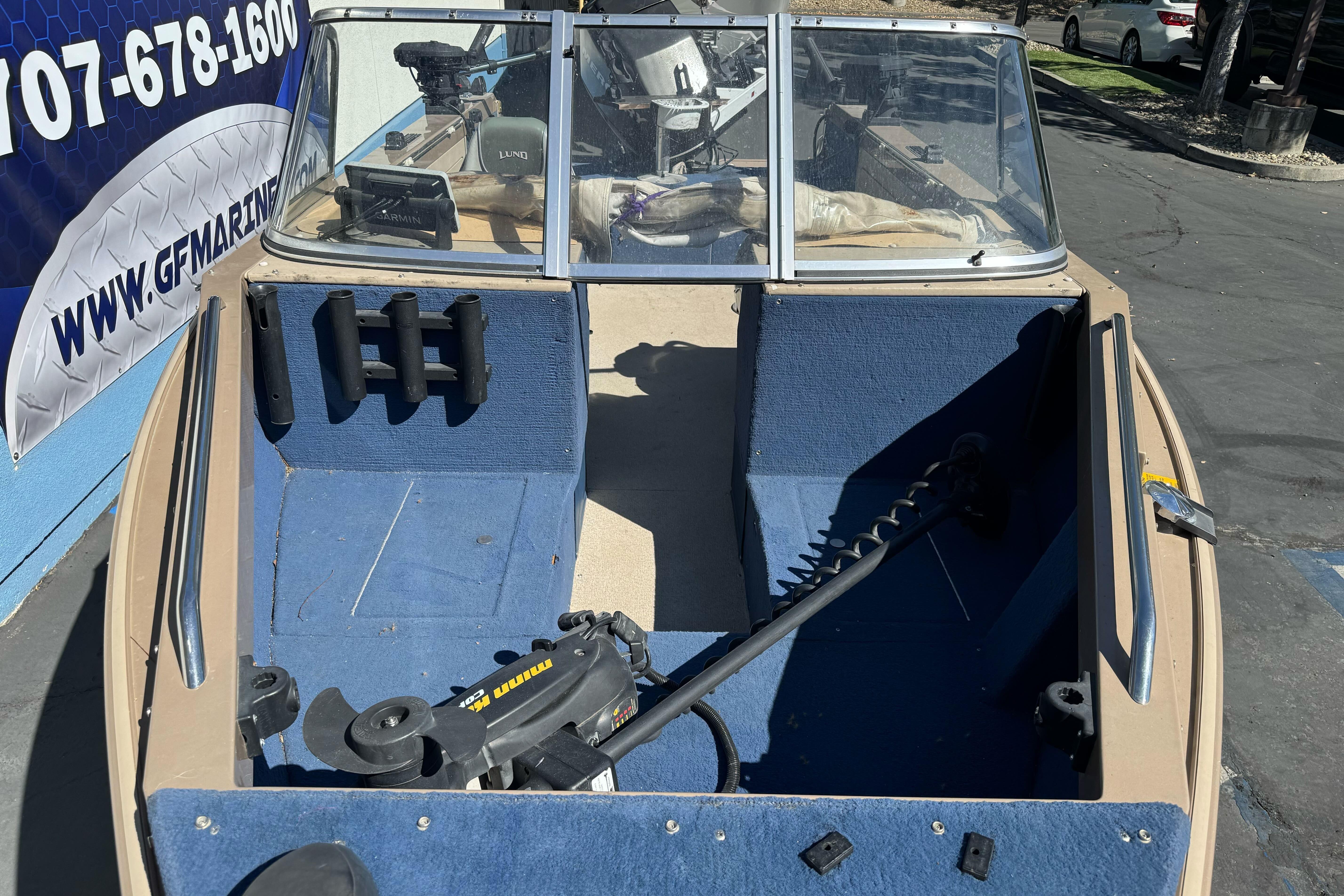 1998 Lund 1700 Pro Sport boat interior with blue carpet and fishing equipment.