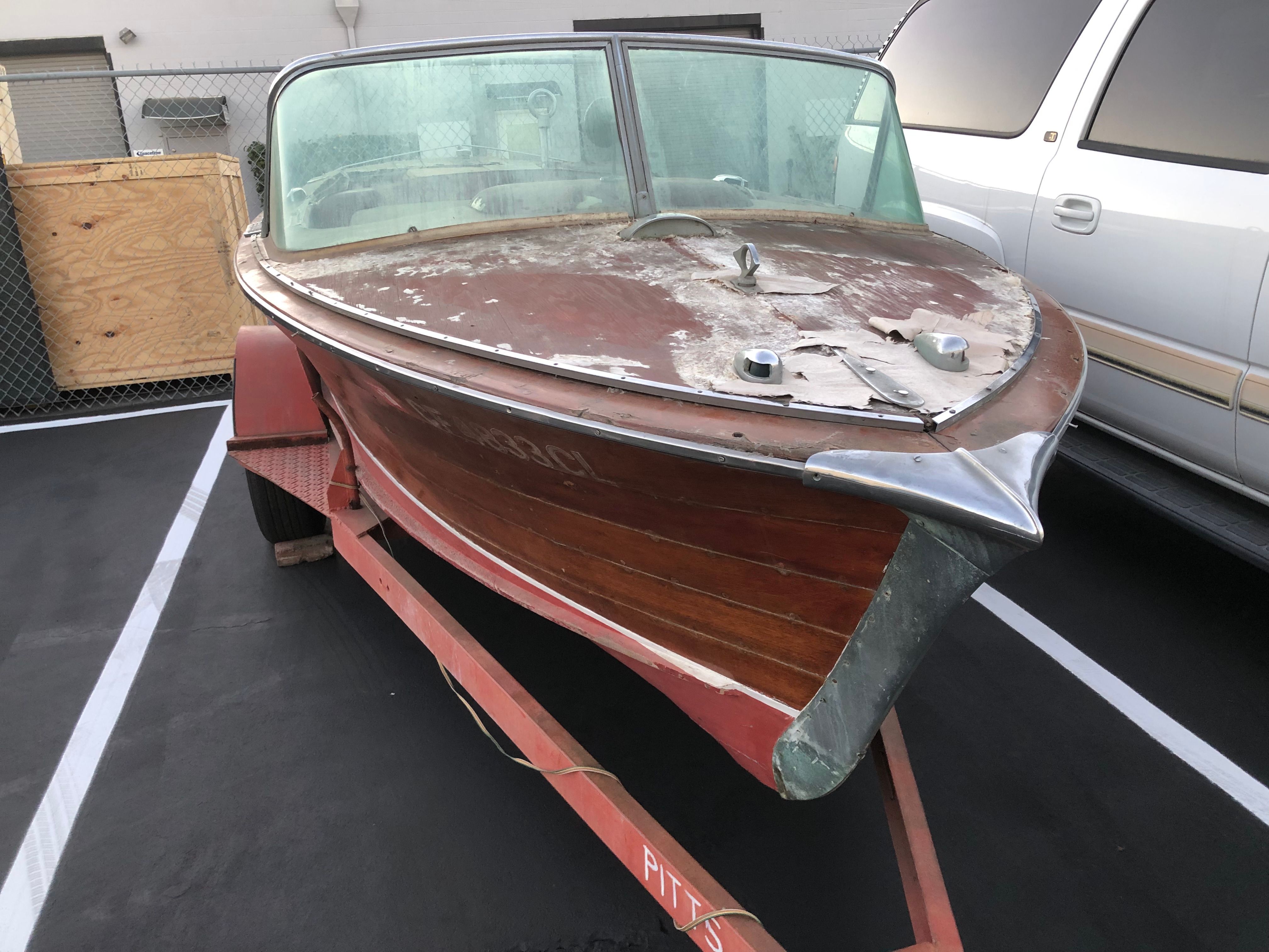A 1960 Century Resorter on a trailer. The wood is worn and weathered.