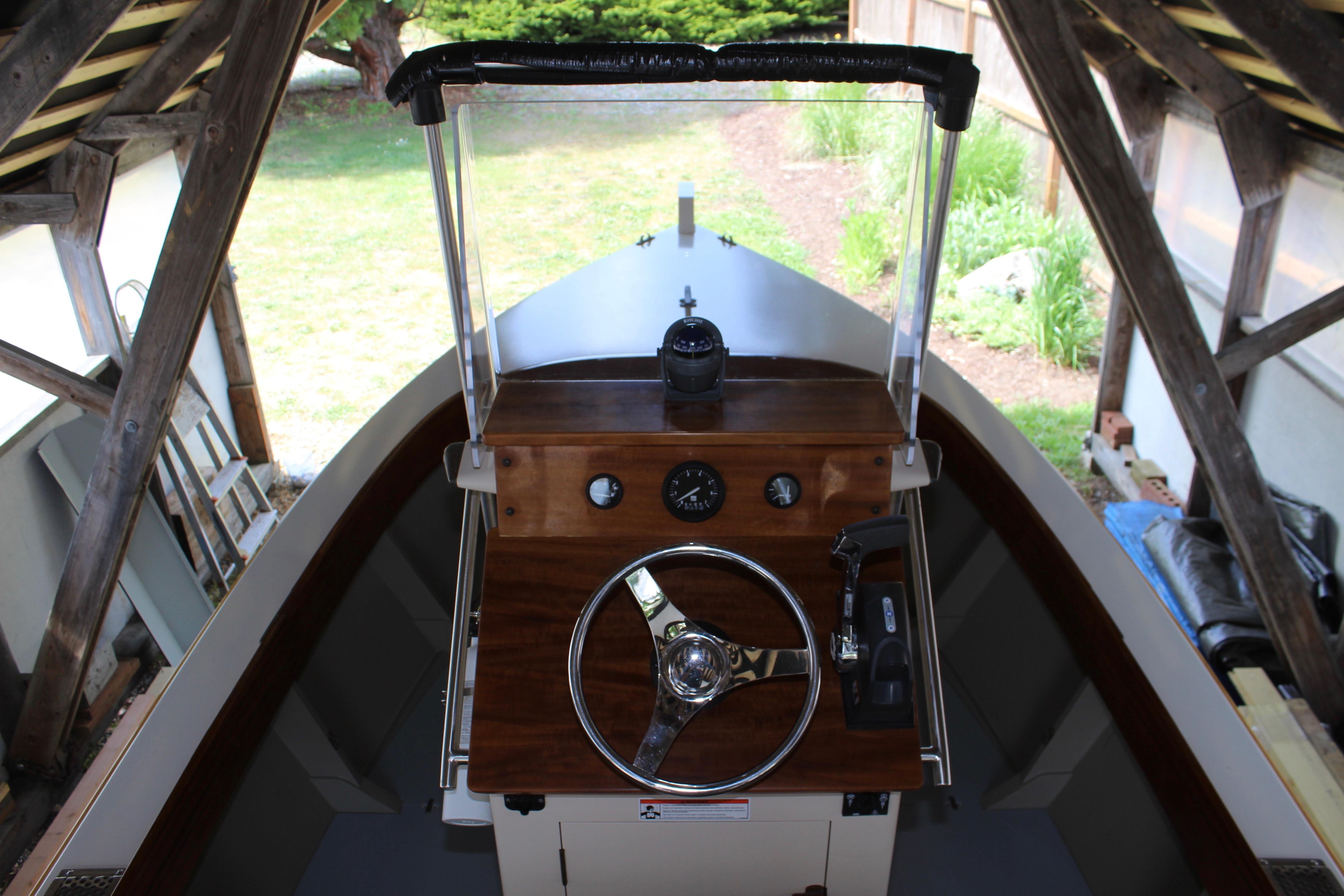 2015 Custom Stambaugh Redwing 18' boat helm with wooden dashboard and steering wheel.