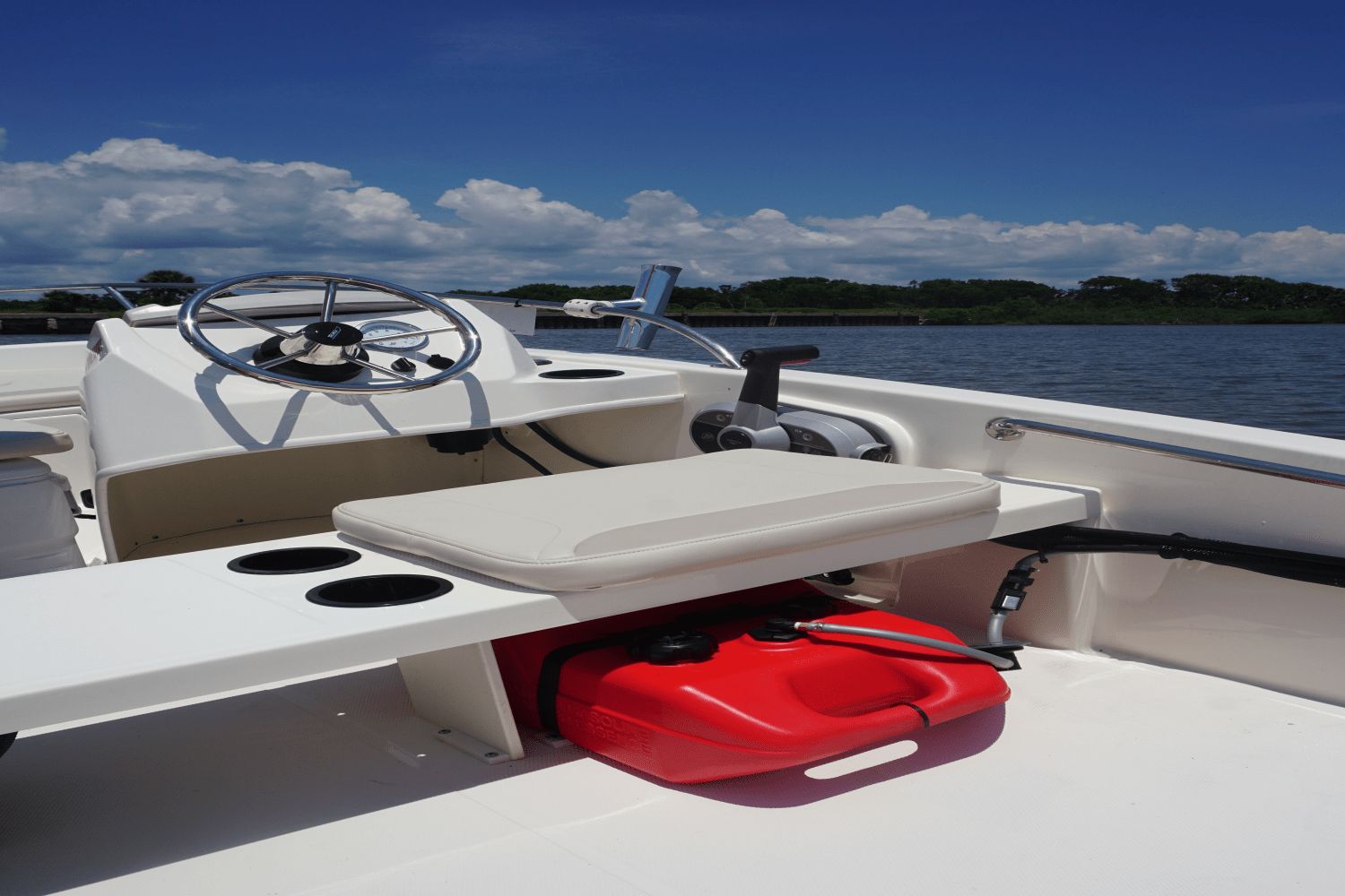 The image shows the cockpit of a Boston Whaler 130 Super Sport with a steering wheel and seat.