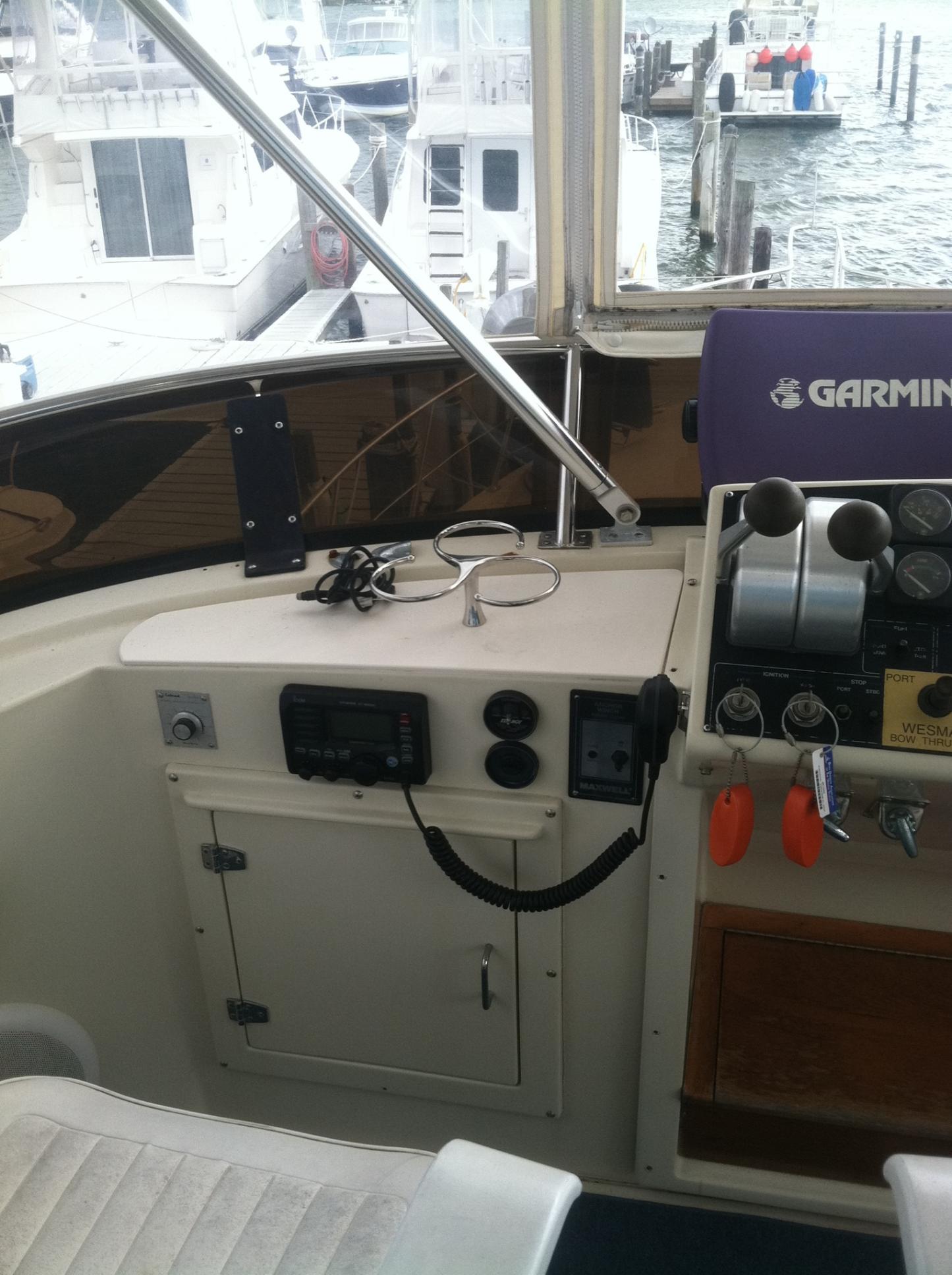 1989 Californian 48 Motor Yacht helm with Garmin navigation system, docked at marina.