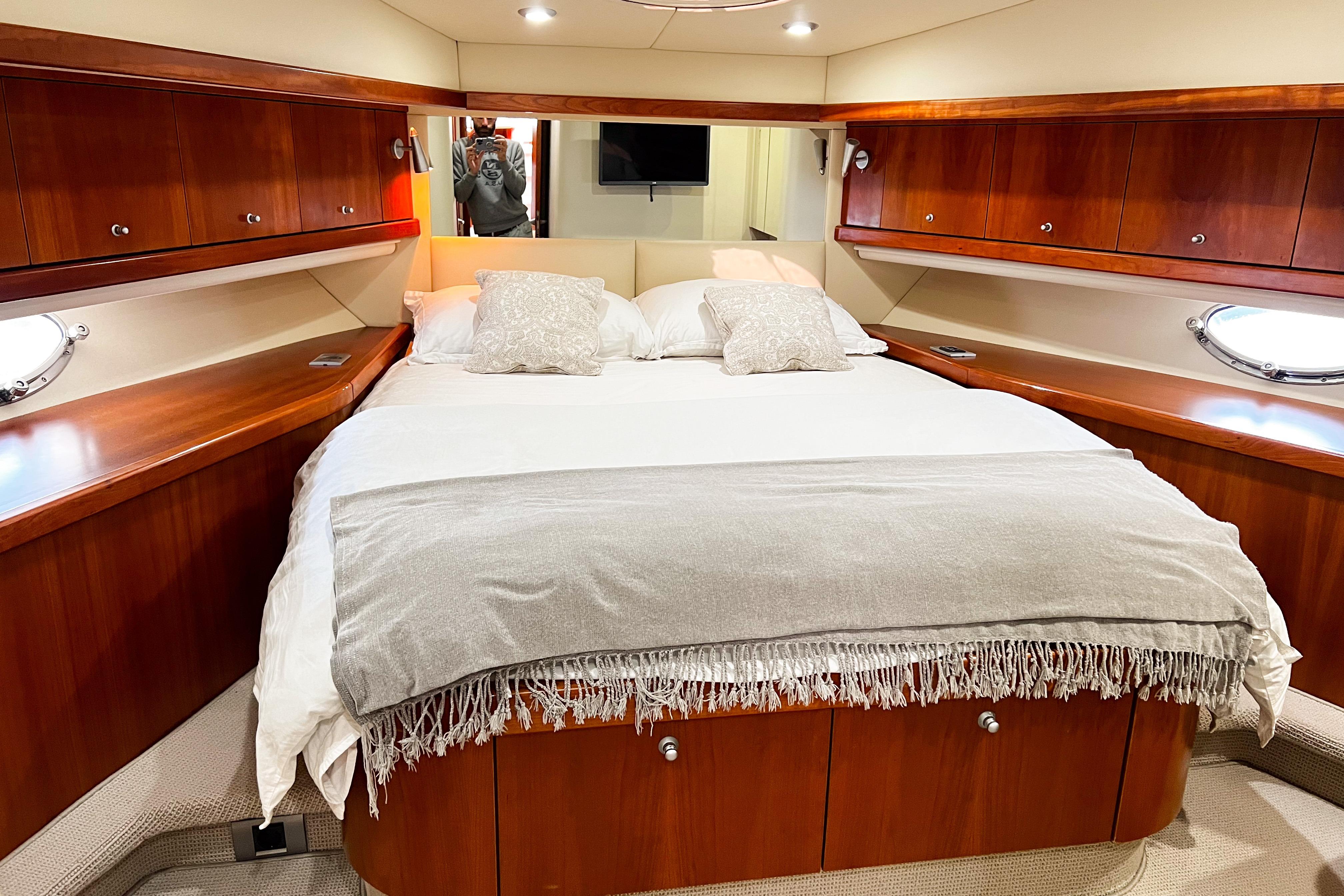 Luxurious bedroom interior of 2007 Sunseeker Manhattan 66 yacht with elegant wood finish.