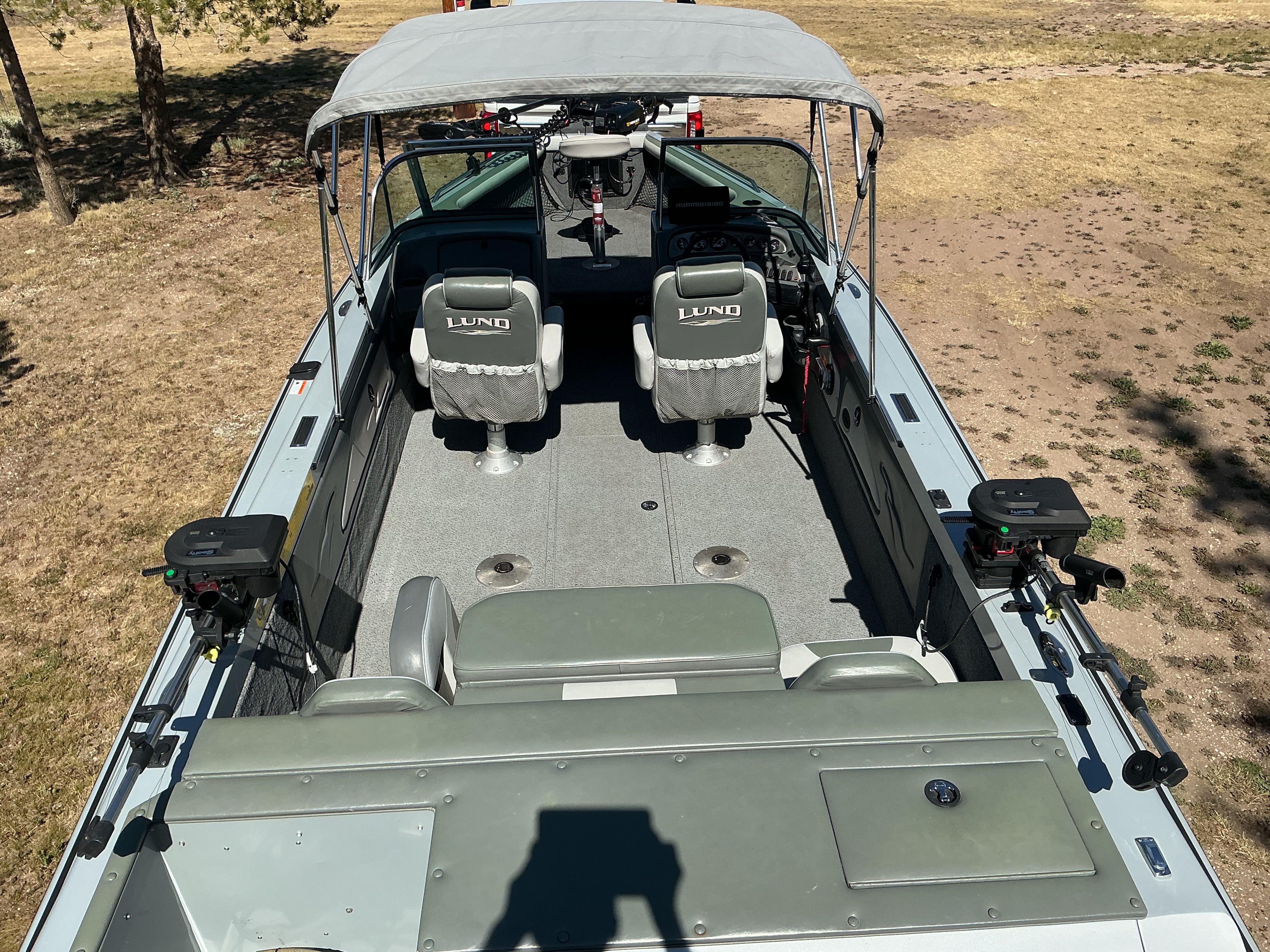 The image shows a 2004 Lund 2150 Baron Magnum ITS boat with gray seats and fishing rod holders.
