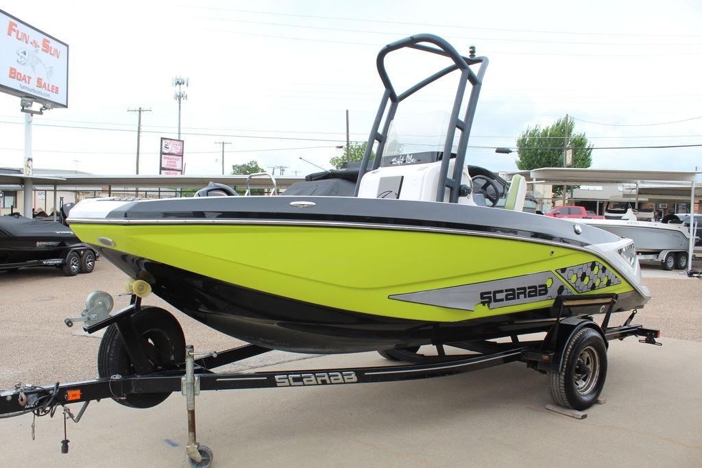 2017 Scarab 195 boat in vibrant yellow on a trailer at a dealership.