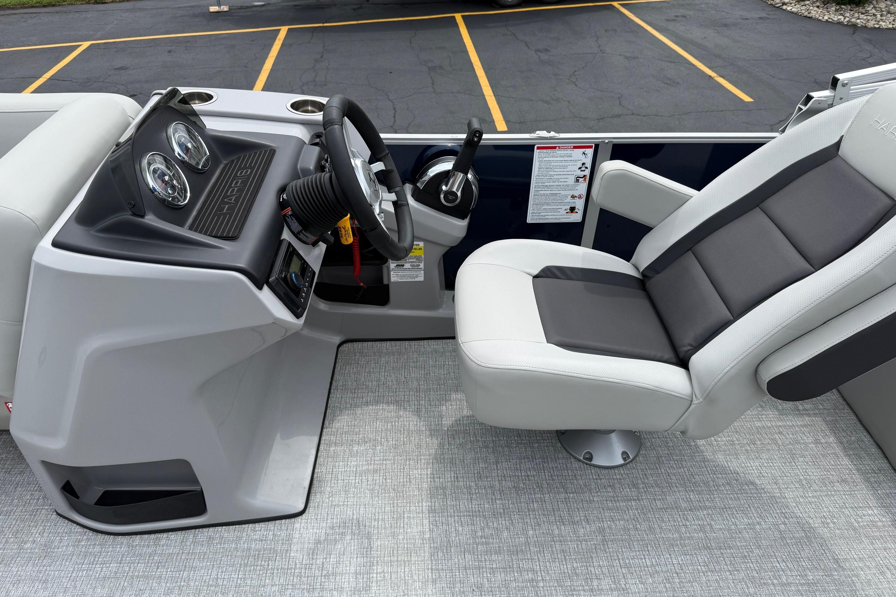 2025 Harris Cruiser 230 boat interior with steering wheel and comfortable seating.