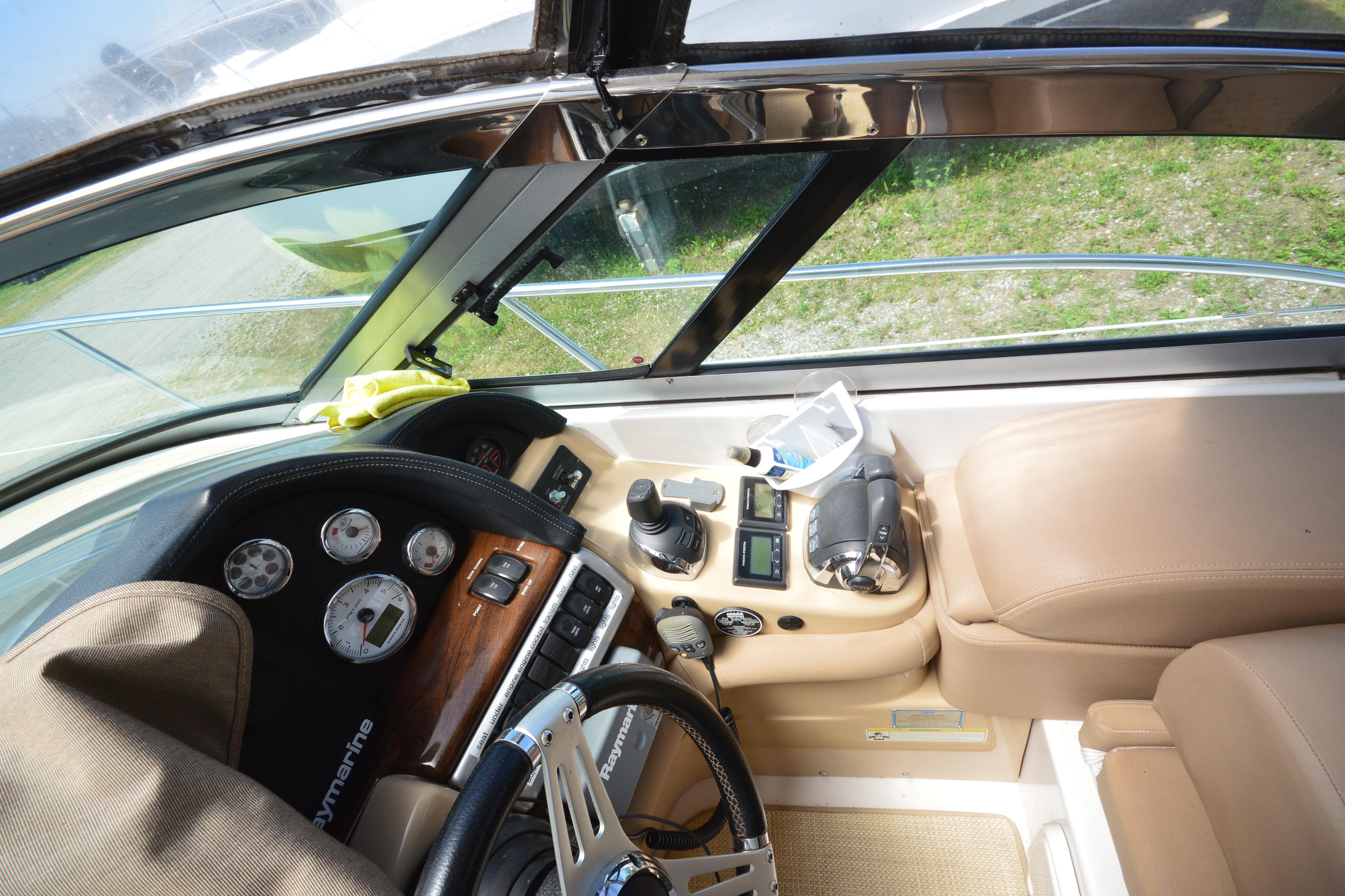 Interior cockpit of 2013 Four Winns V375 boat with steering wheel and control panel.