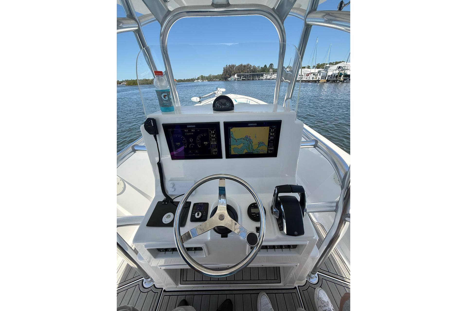 2021 Custom Infusion 34 CC boat dashboard with navigation screens and steering wheel.