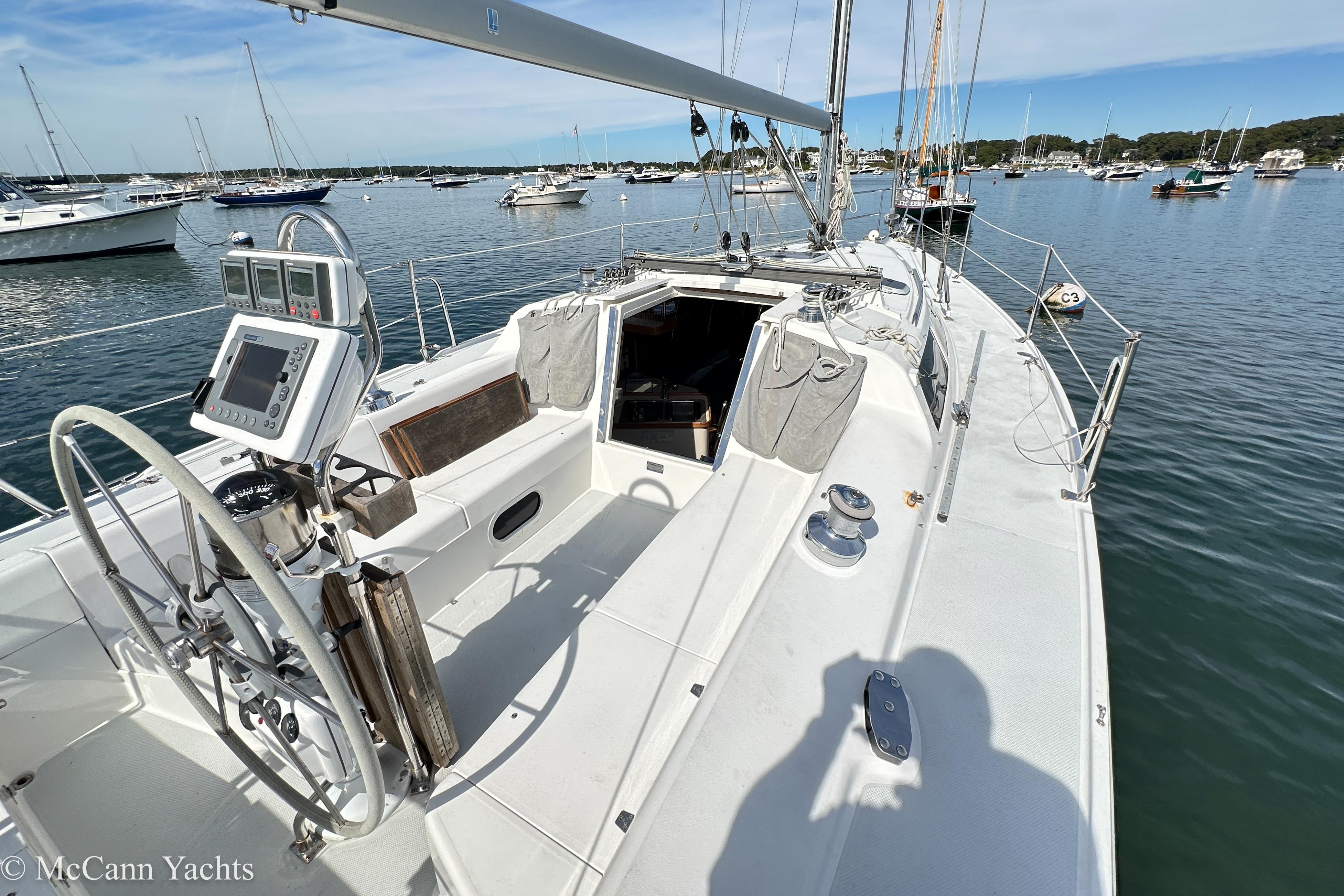 2003 Catalina 320 sailboat cockpit with navigation equipment, docked in a serene marina.