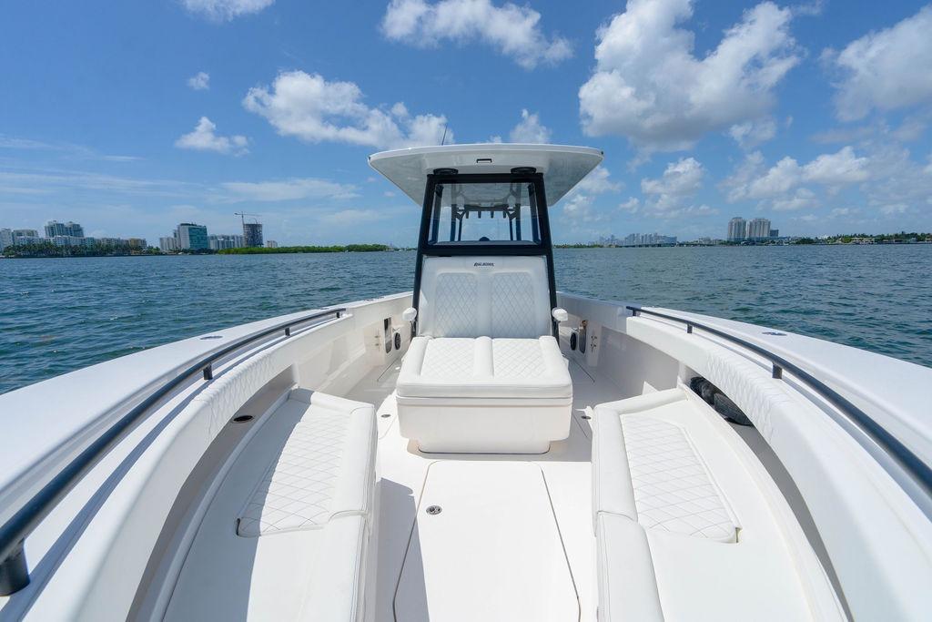 2027 Reef Runner 340 boat on water, clear sky, city skyline in background.
