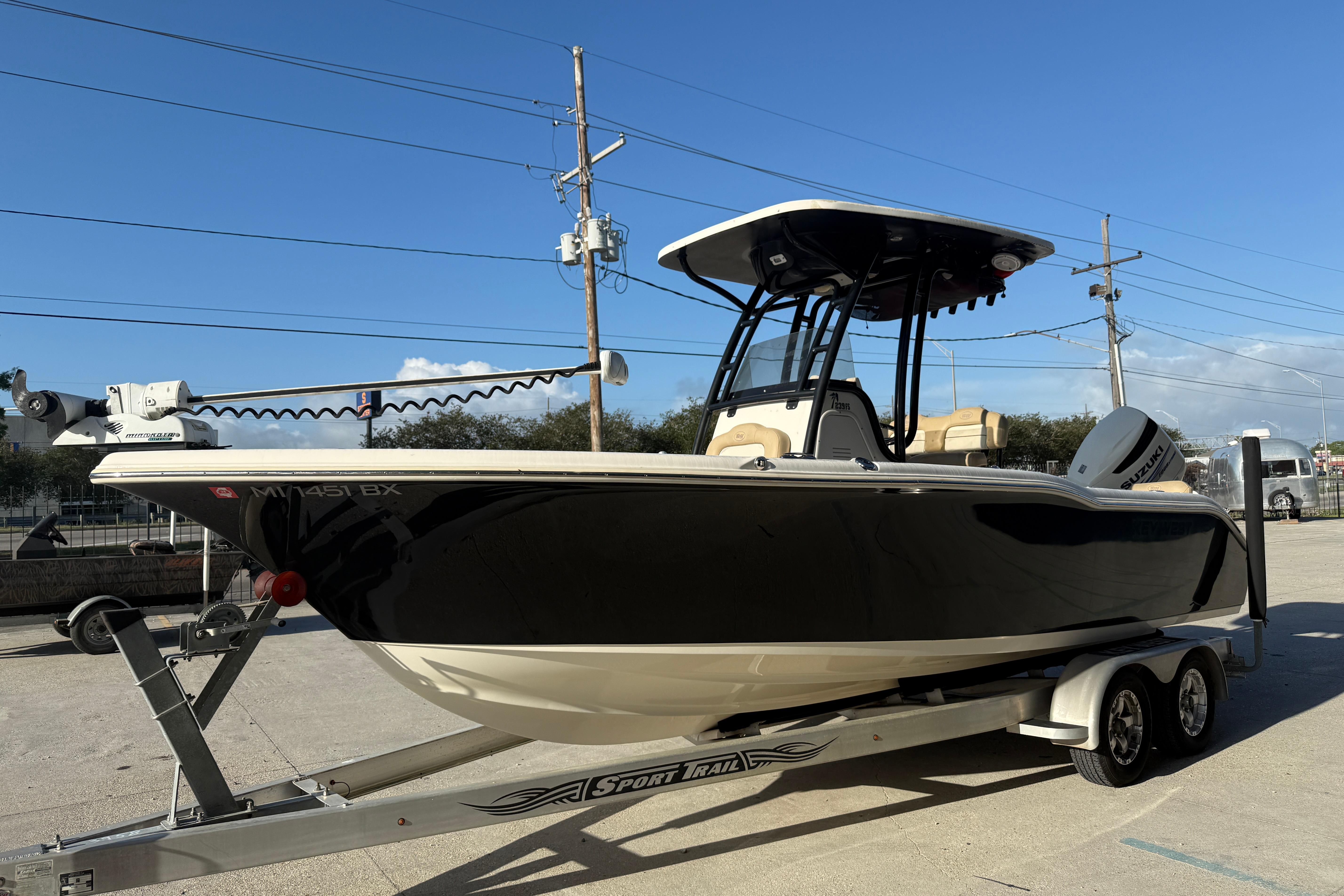 2016 Key West 239 FS boat on trailer, black hull, clear sky background.