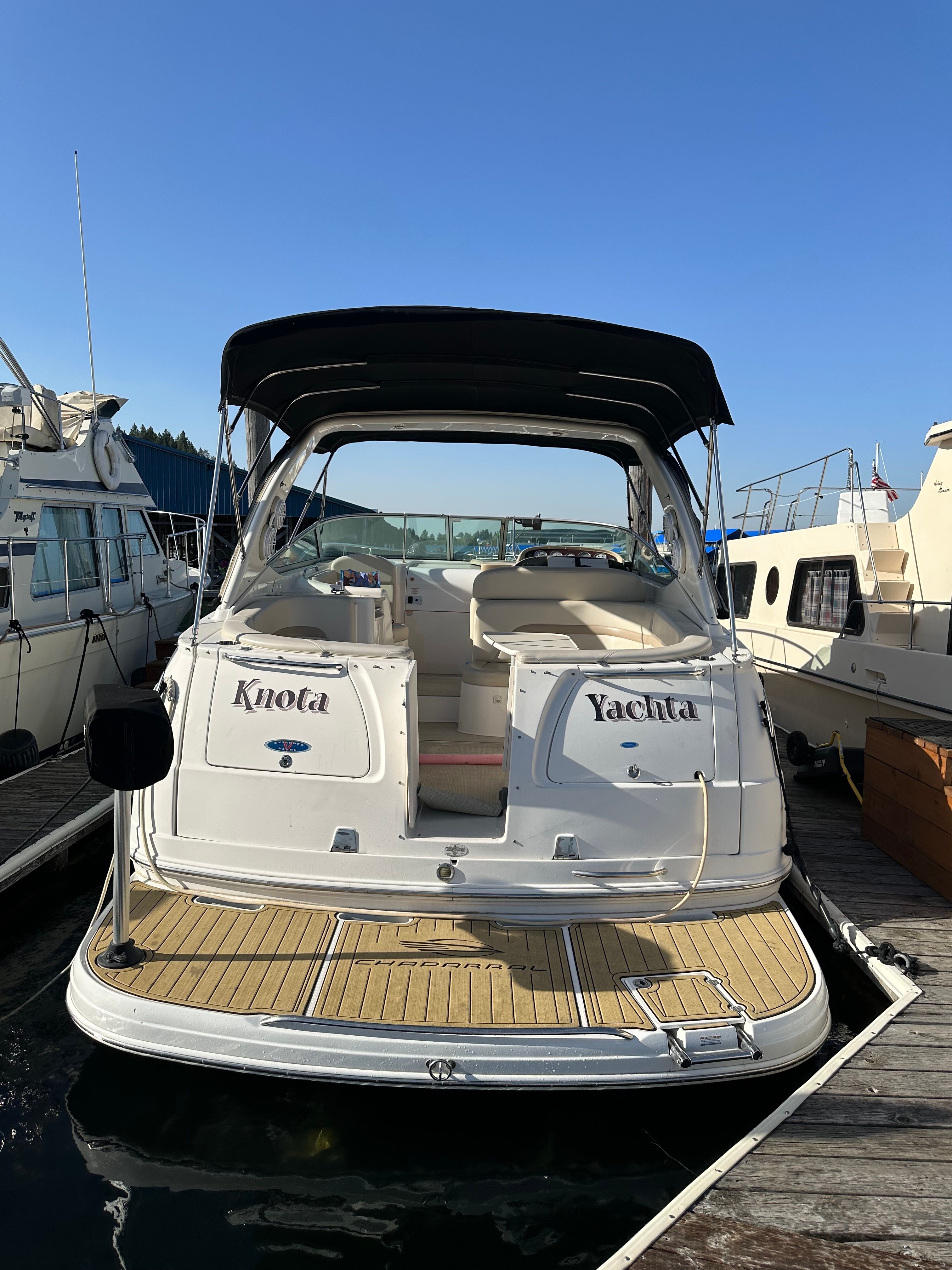A 2004 Chaparral Signature 330 docked. It features an open cockpit and a black canopy.