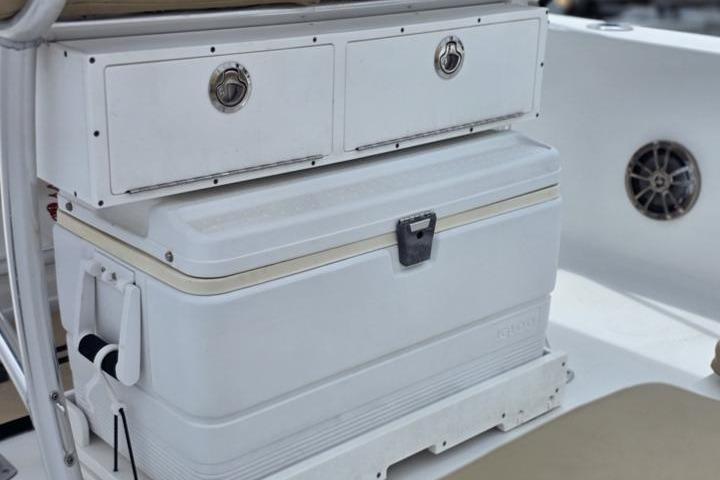 2016 Sportmans Masters 227 Bay Boat interior with storage compartments and cooler.