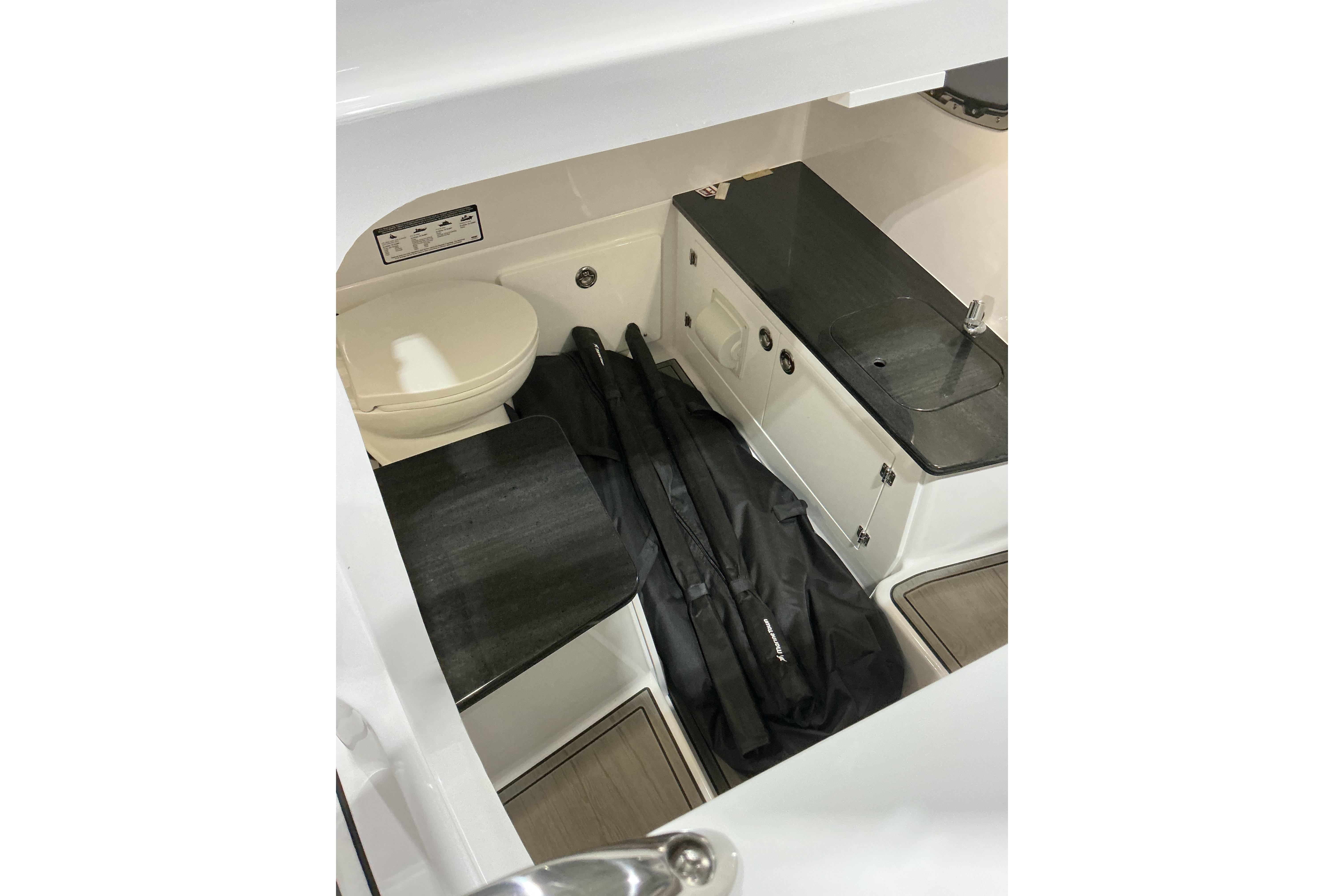 2026 Monterey Elite 25 SD boat interior with toilet and storage area.