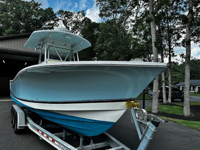 2008 Regulator 29 Forward Seating boat on trailer, parked outdoors near trees.