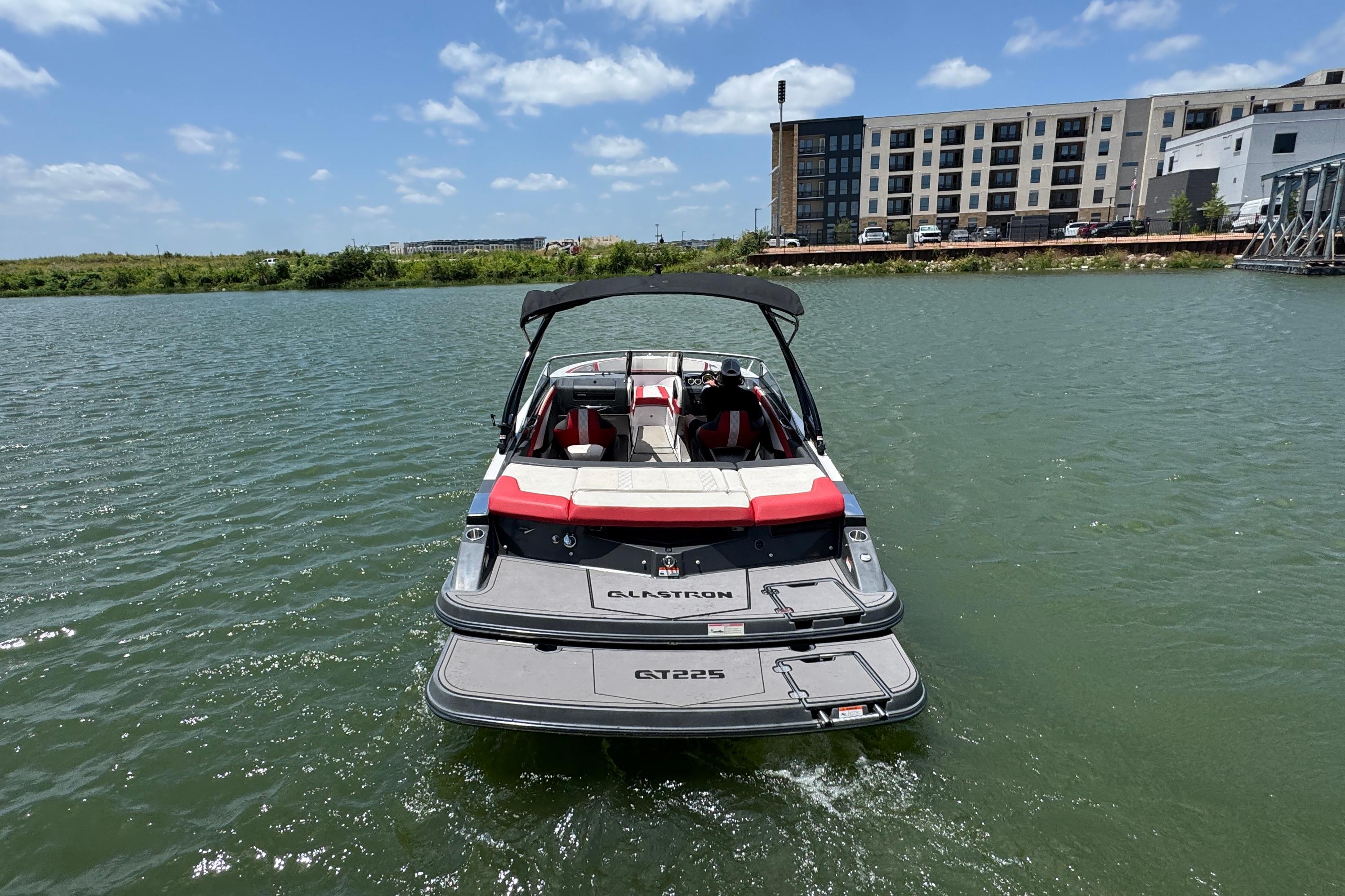 2017 Glastron GT 225 boat on water, with modern buildings in the background.