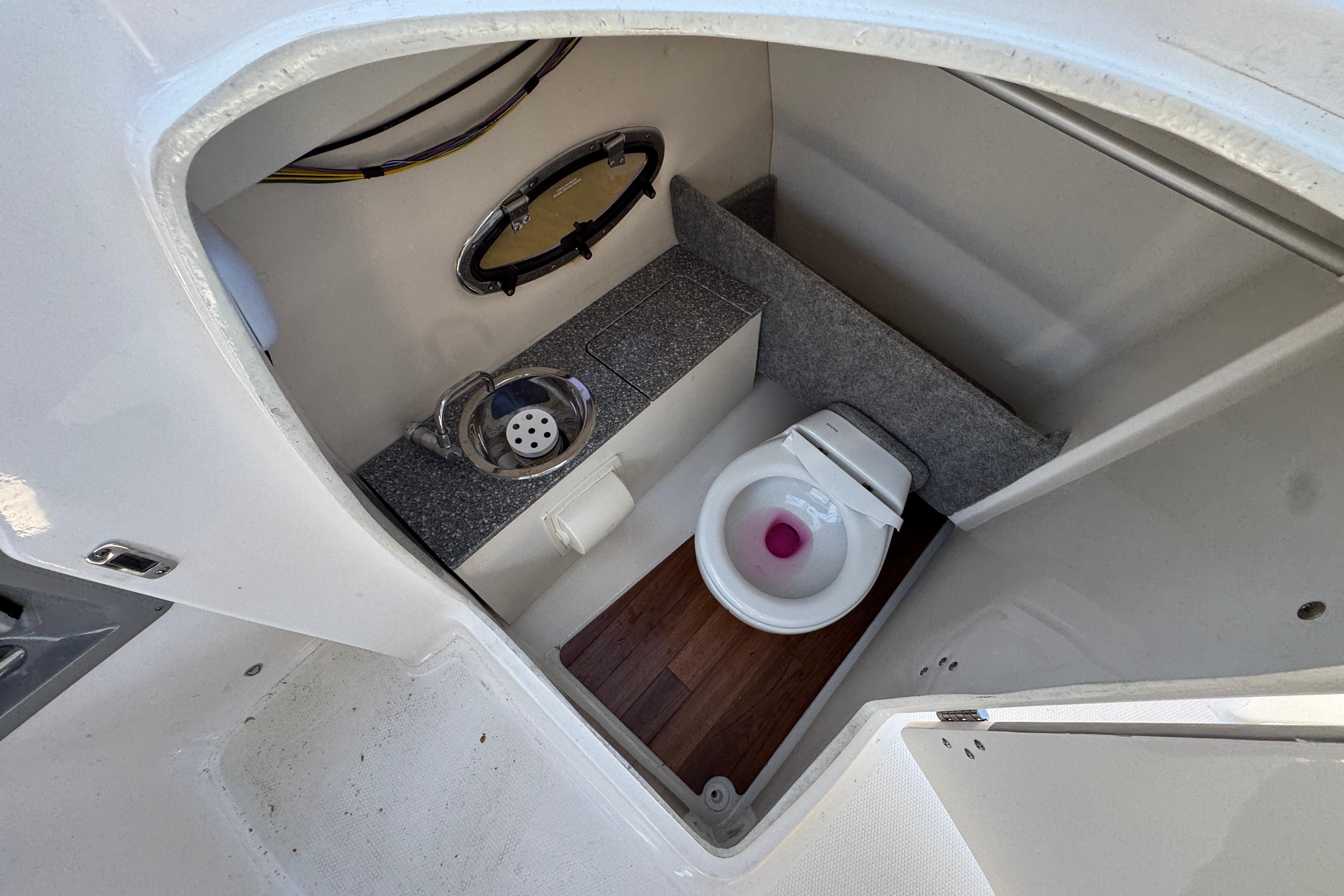2018 Chaparral 250 Suncoast boat interior with compact bathroom and toilet.