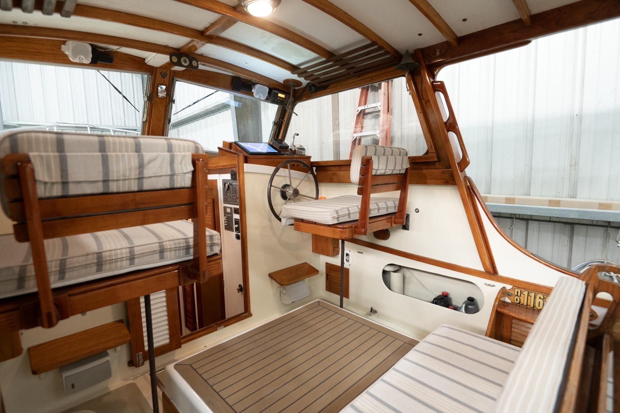 1986 Dyer Hardtop boat interior with striped seating and wooden accents.