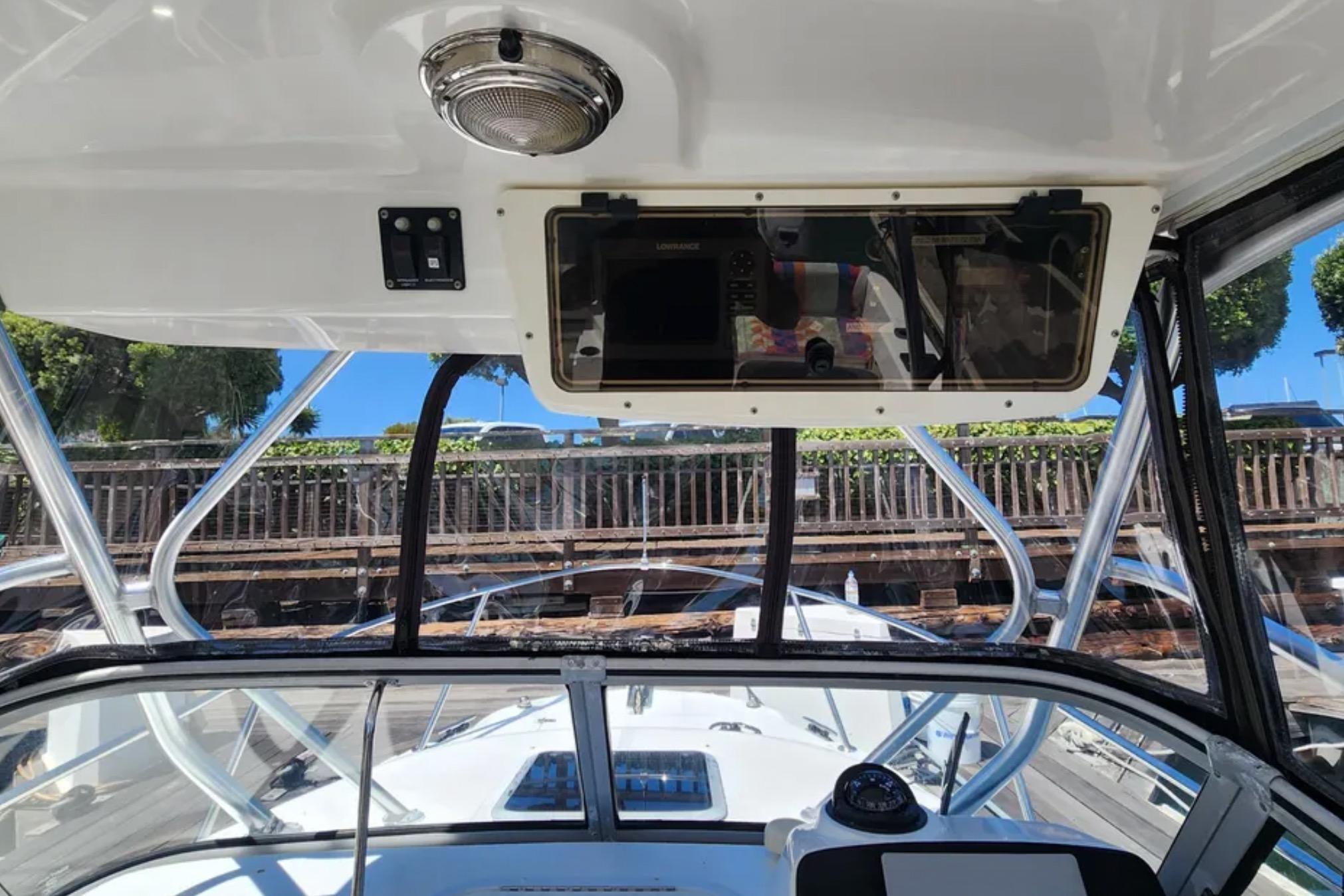 Interior view of a 2000 Boston Whaler 21 Conquest boat, showcasing the helm and windshield.