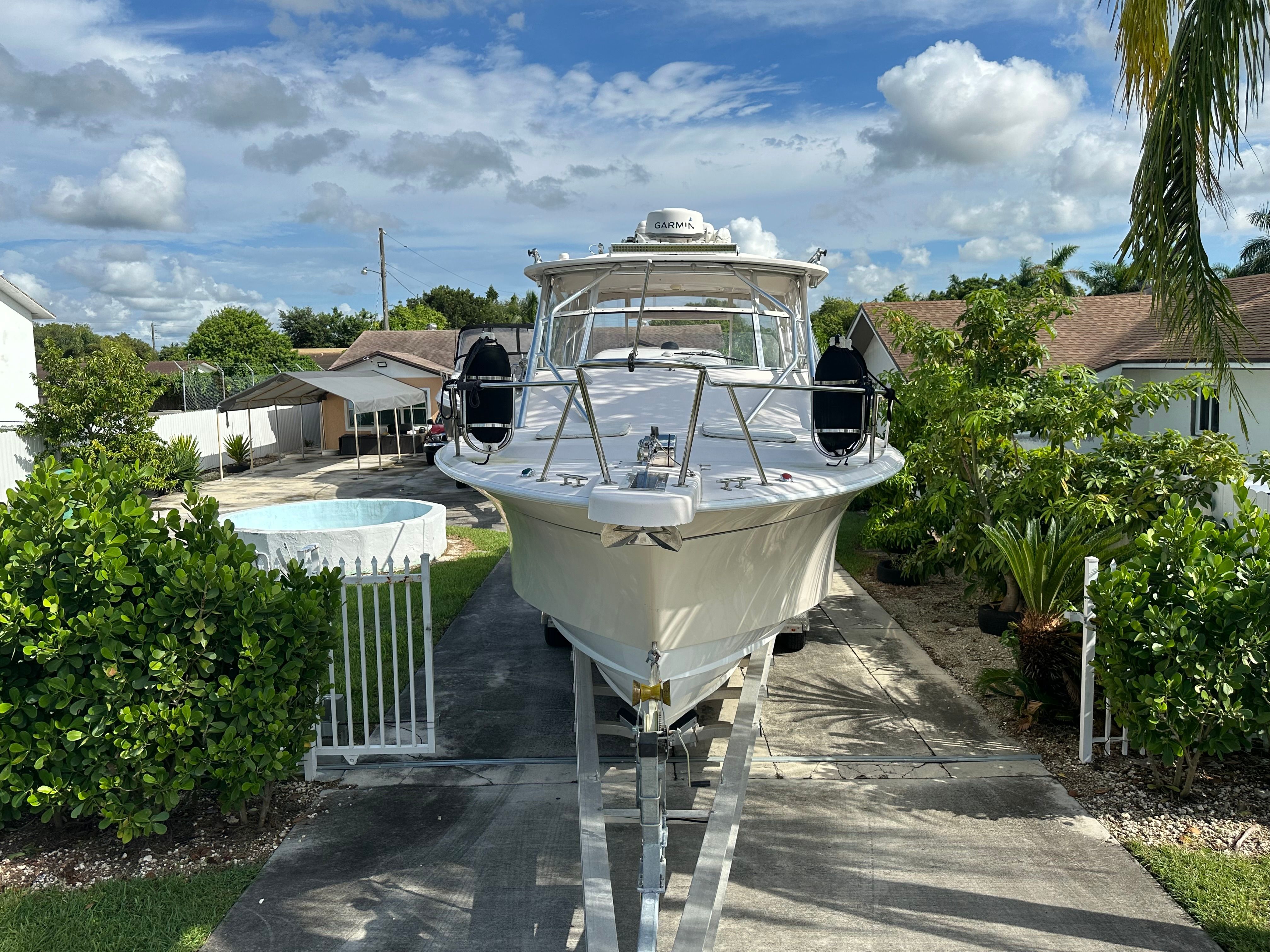 2003 Grady-White Express 330 on a trailer in a garden setting.