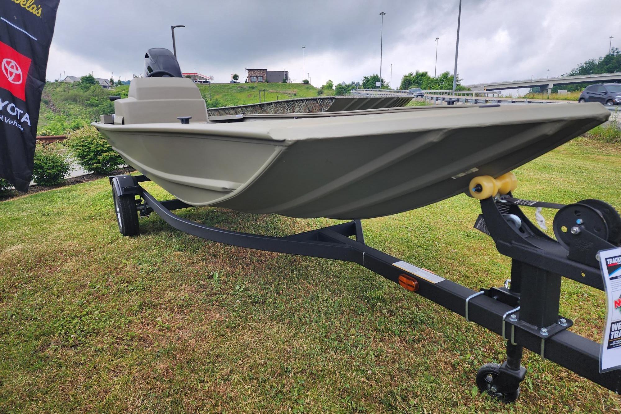 2026 Tracker Grizzly 1648 SC boat on trailer, displayed outdoors on grass.