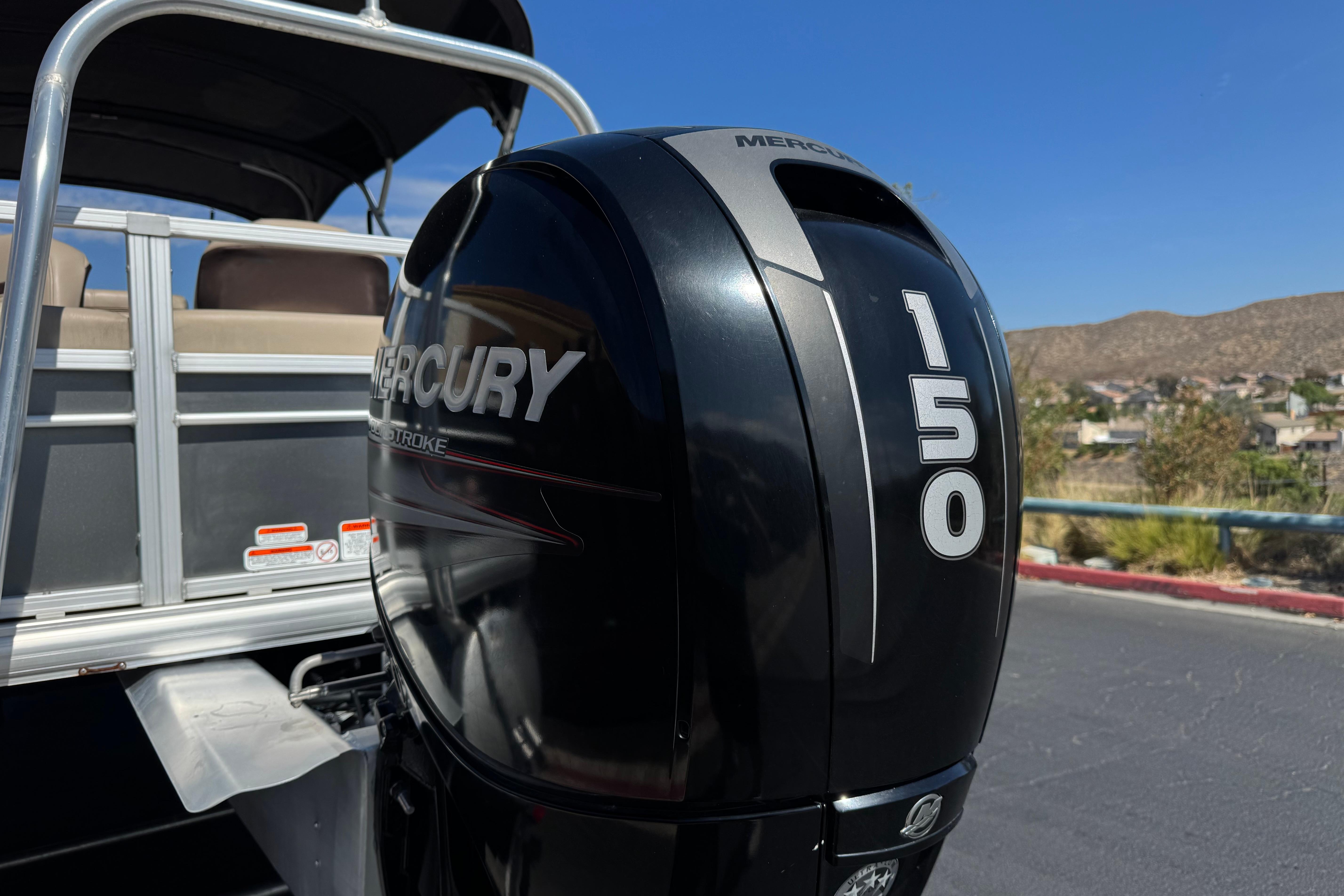 2018 Sun Tracker SportFish 22 DLX with Mercury 150 outboard motor, parked outdoors.