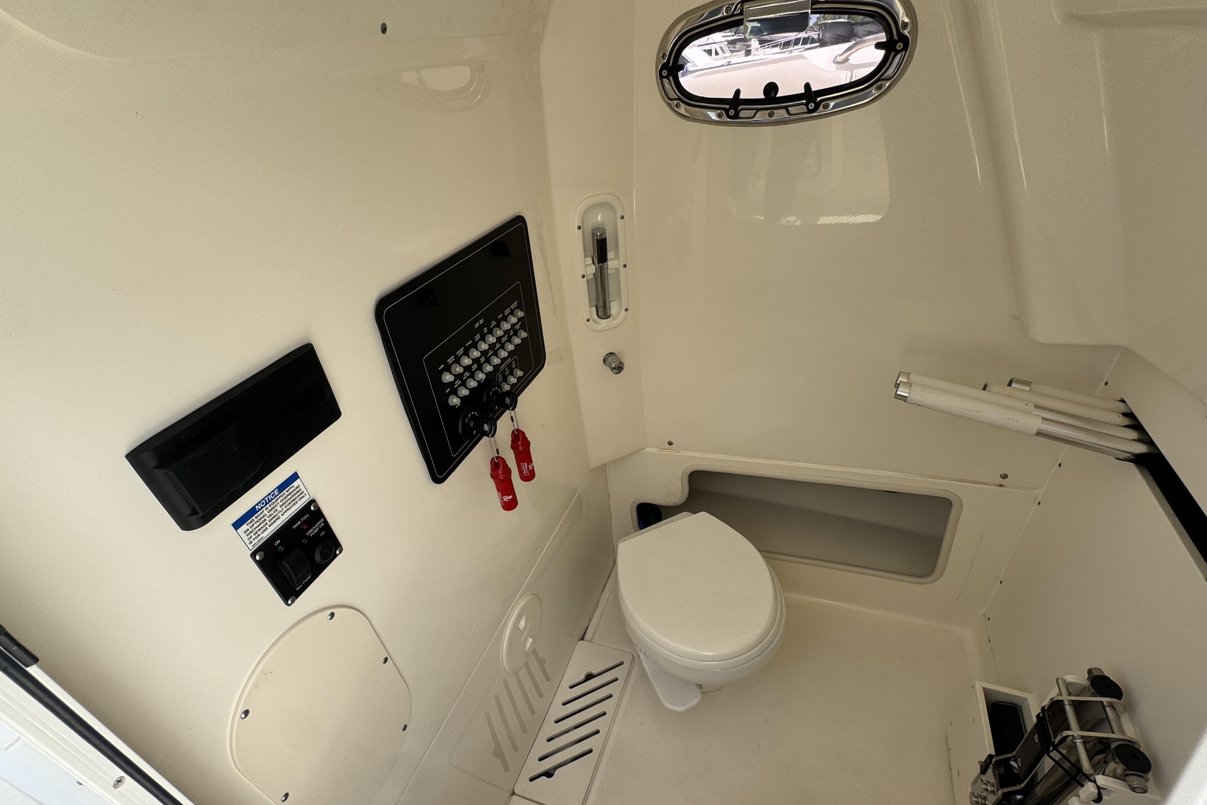 2022 Boston Whaler 280 Outrage interior cabin with toilet and control panel.