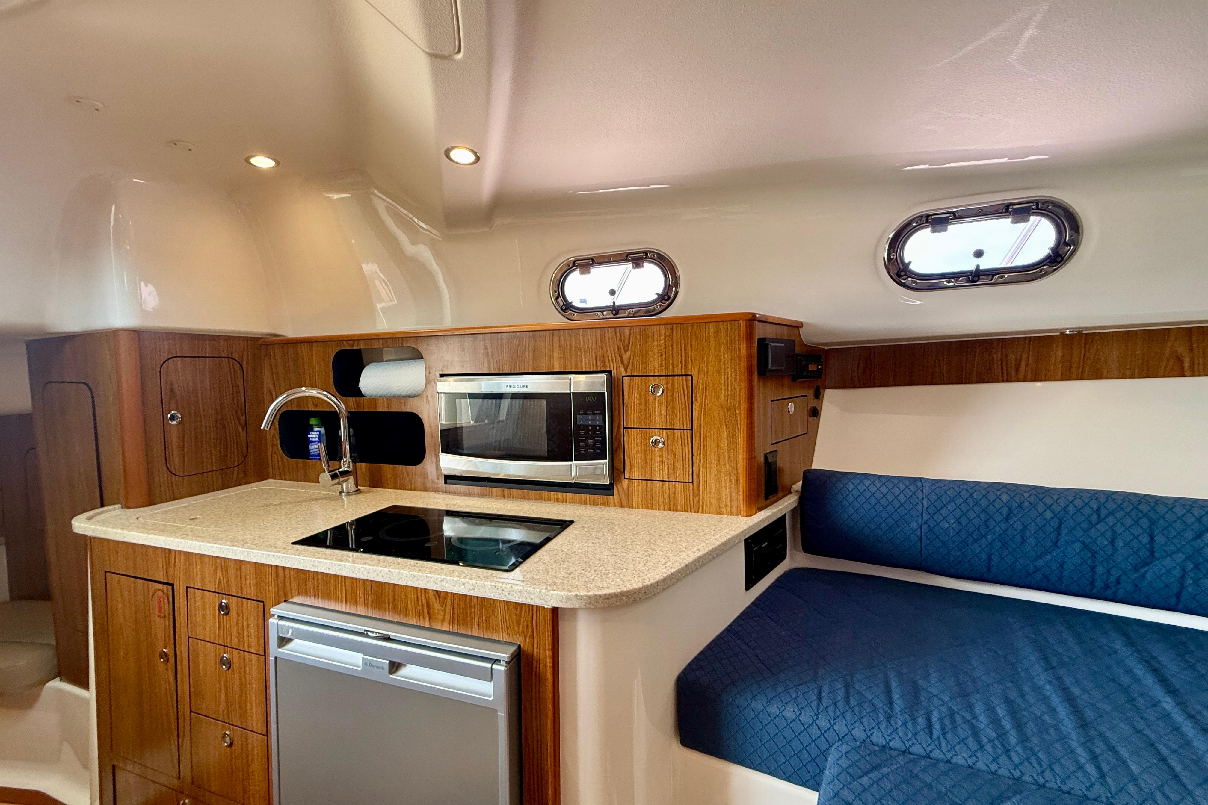 2012 Pursuit OS 345 Offshore yacht interior with kitchenette and seating area.