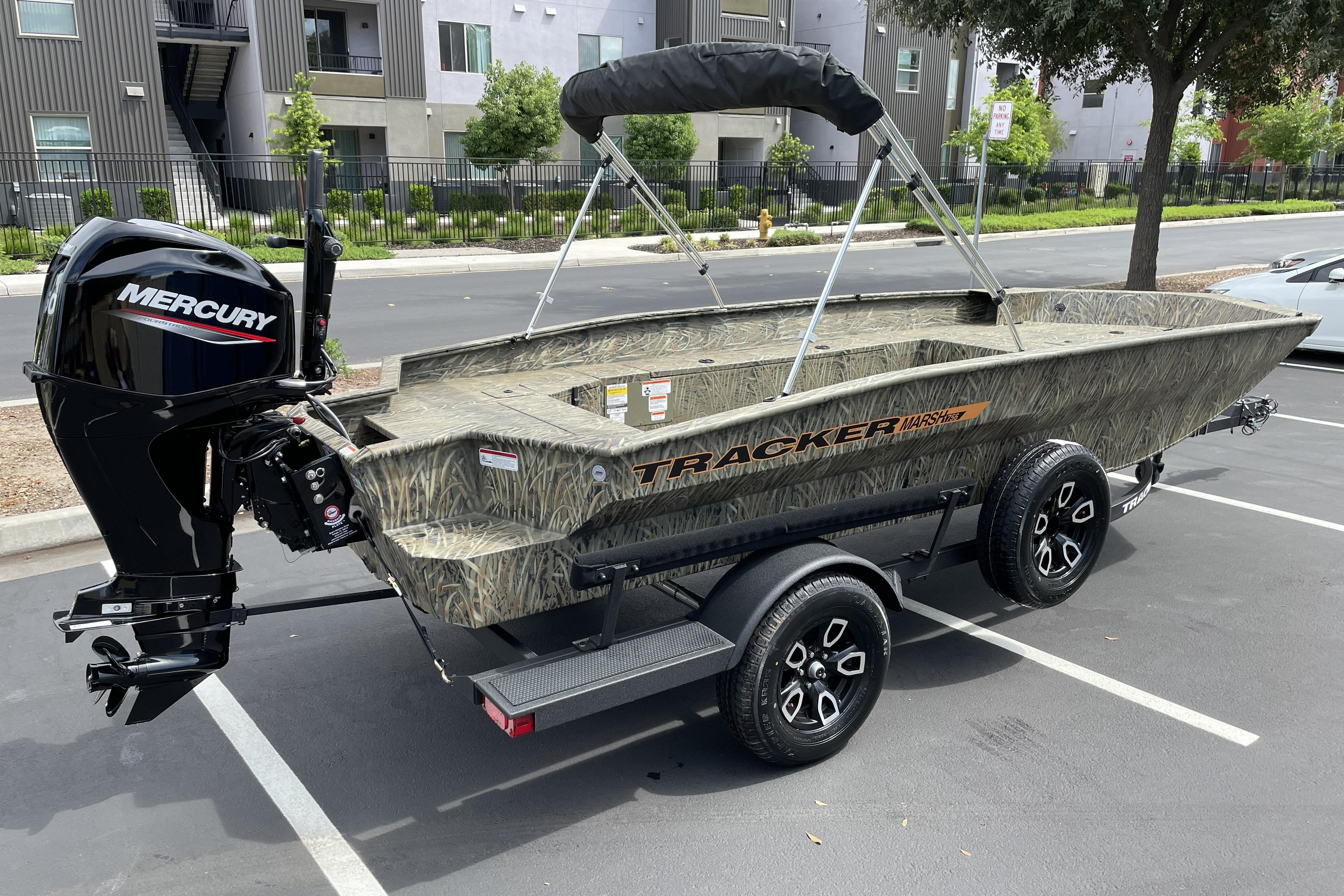 2026 Tracker Grizzly 1756 T Marsh boat with Mercury engine on trailer in parking lot.