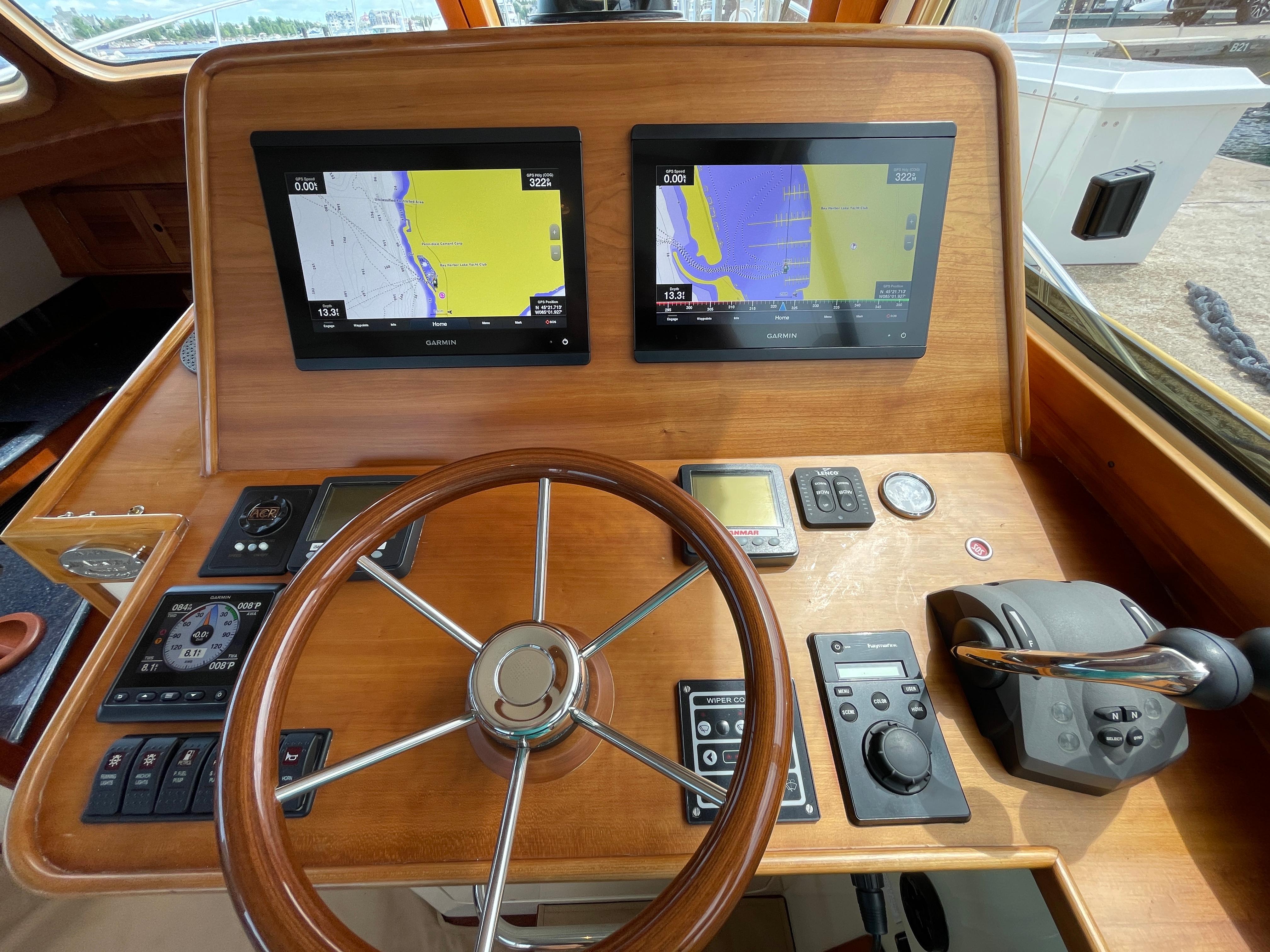 Helm of 2007 Hinckley Talaria 44 Flybridge with dual navigation screens and wooden steering wheel.