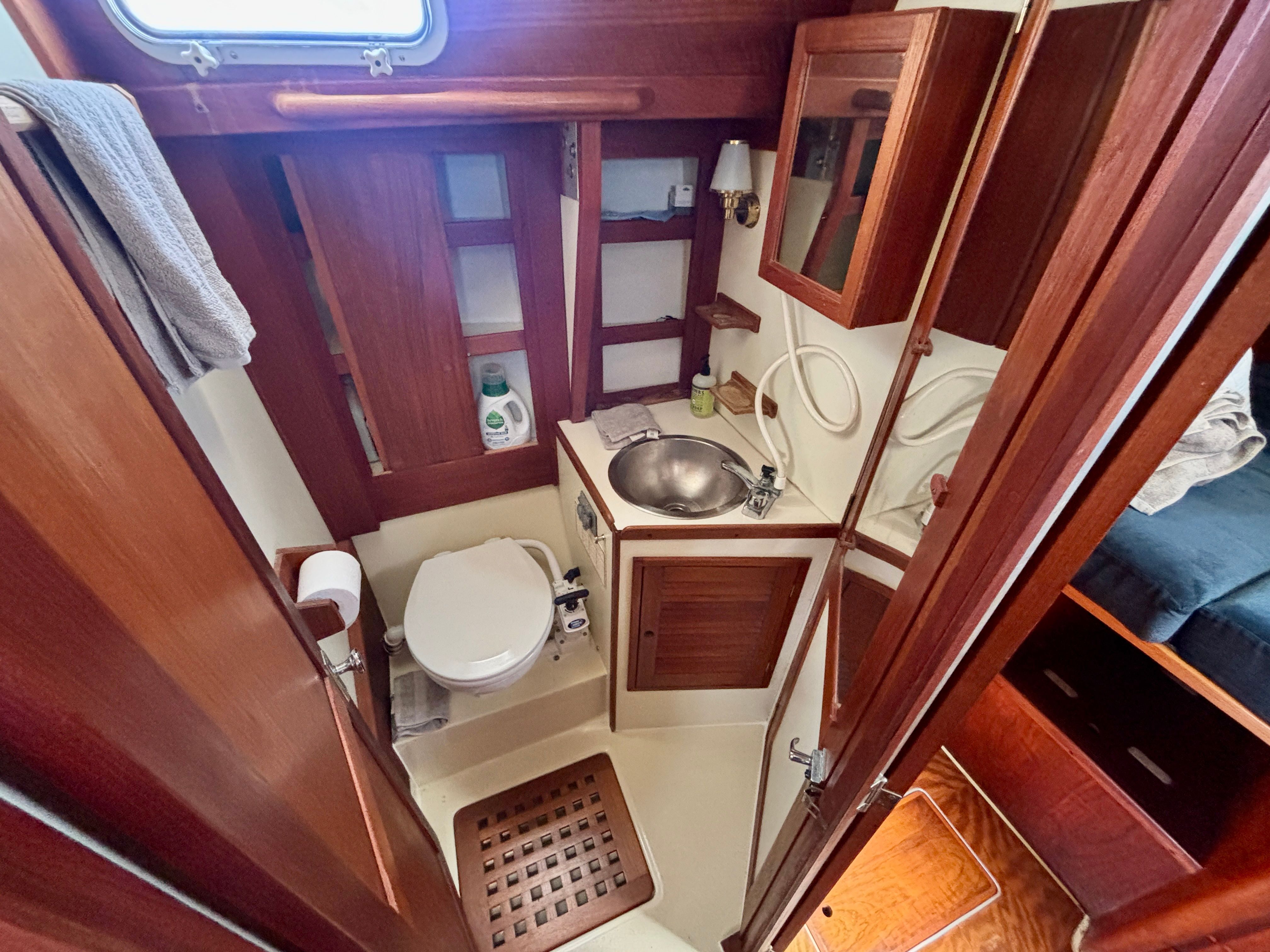 The image shows the bathroom of a 1979 Tartan 37 with wood paneling and a sink.