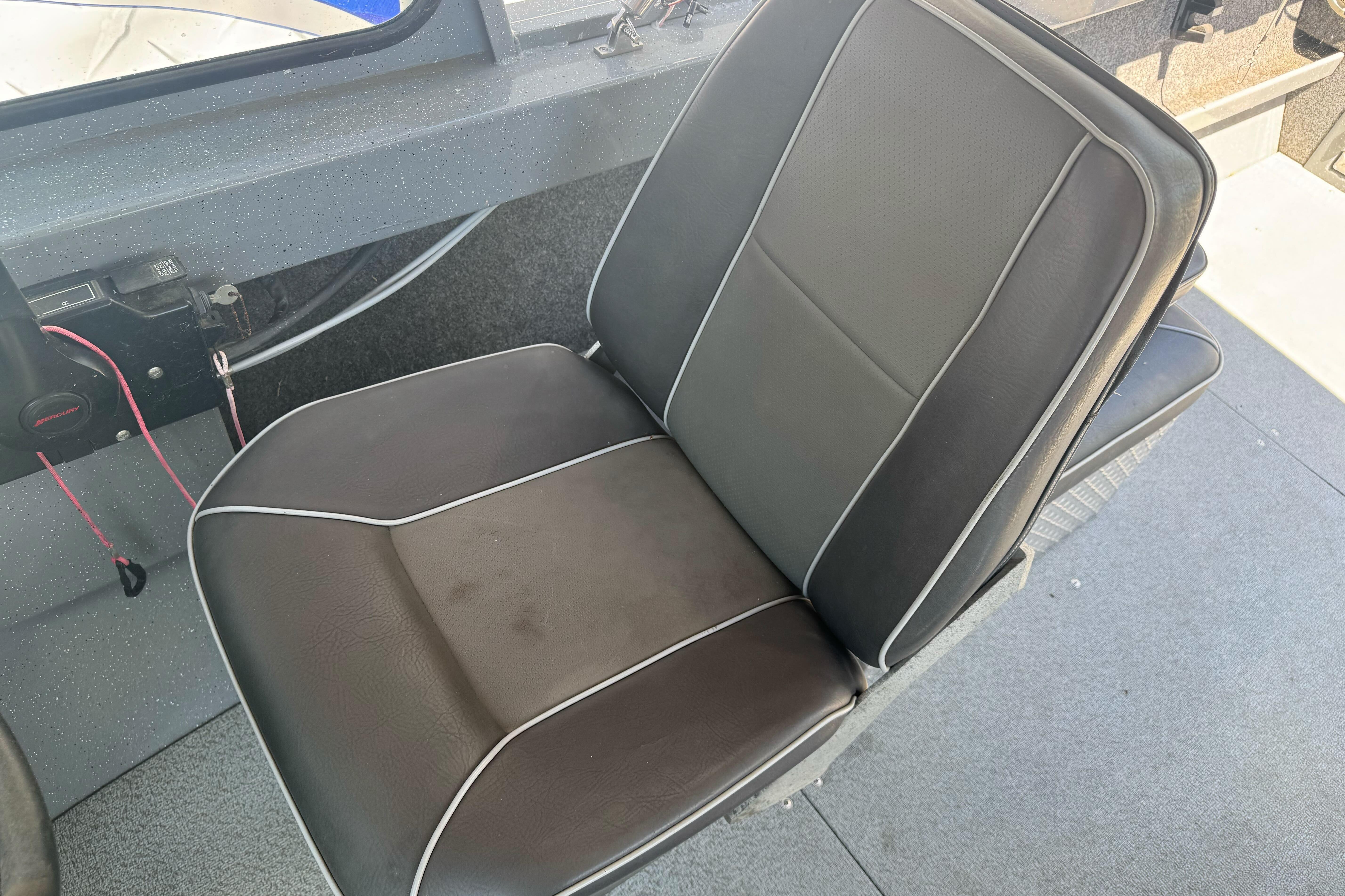 Black cushioned seat in a 2014 River Hawk 19 GB boat interior.