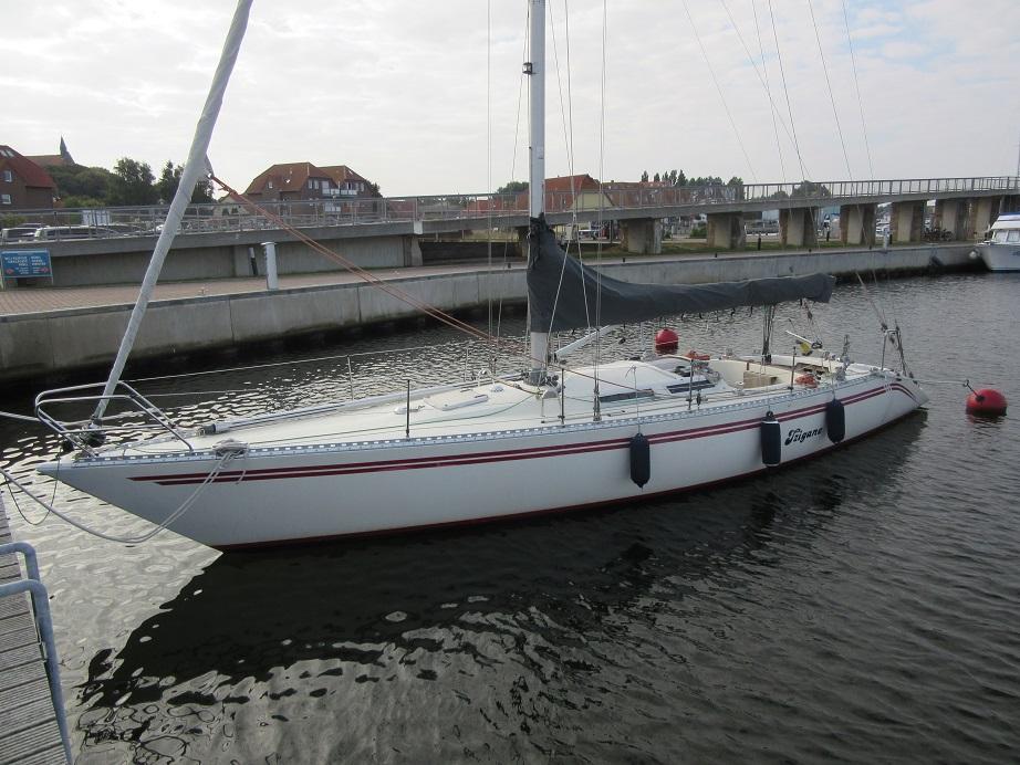 1986 Comfortina Cayenne 42 sailboat docked in a marina, calm water, overcast sky.