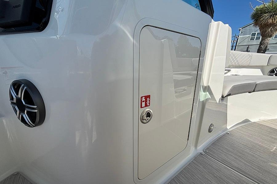 2027 Sea Ray SDX 230 Outboard boat interior with storage compartment and speaker.