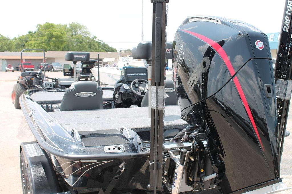 2025 Phoenix 920 Elite boat with powerful outboard motor, parked outdoors.