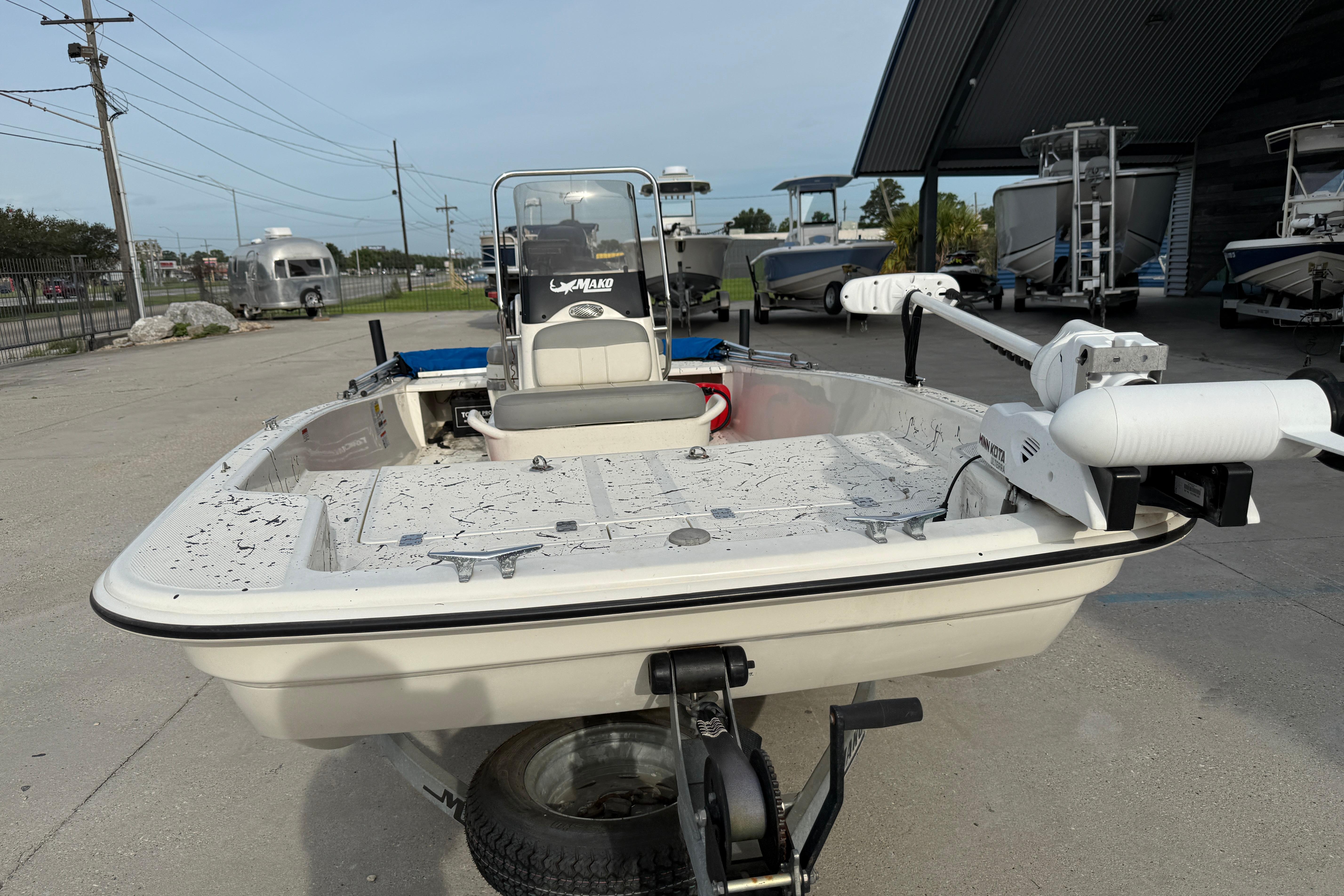 2020 Mako Pro Skiff 15 CC boat on trailer, parked outdoors near other boats.