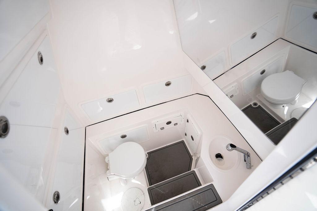 Modern bathroom interior of 2027 Reef Runner 340 boat, featuring toilet and sink.