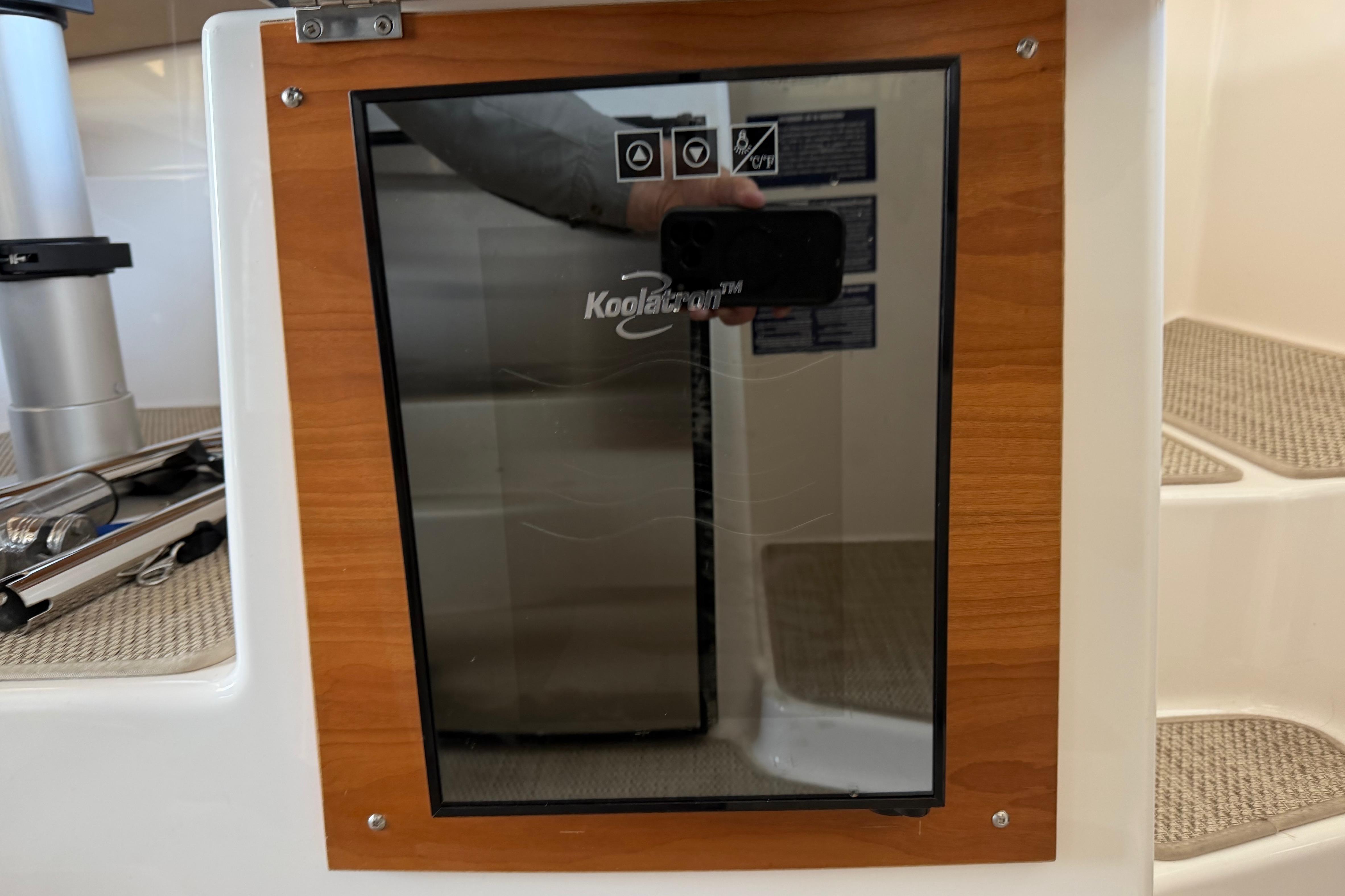 2023 Cutwater C-288 Coupe interior with Koolatron fridge and wooden paneling.