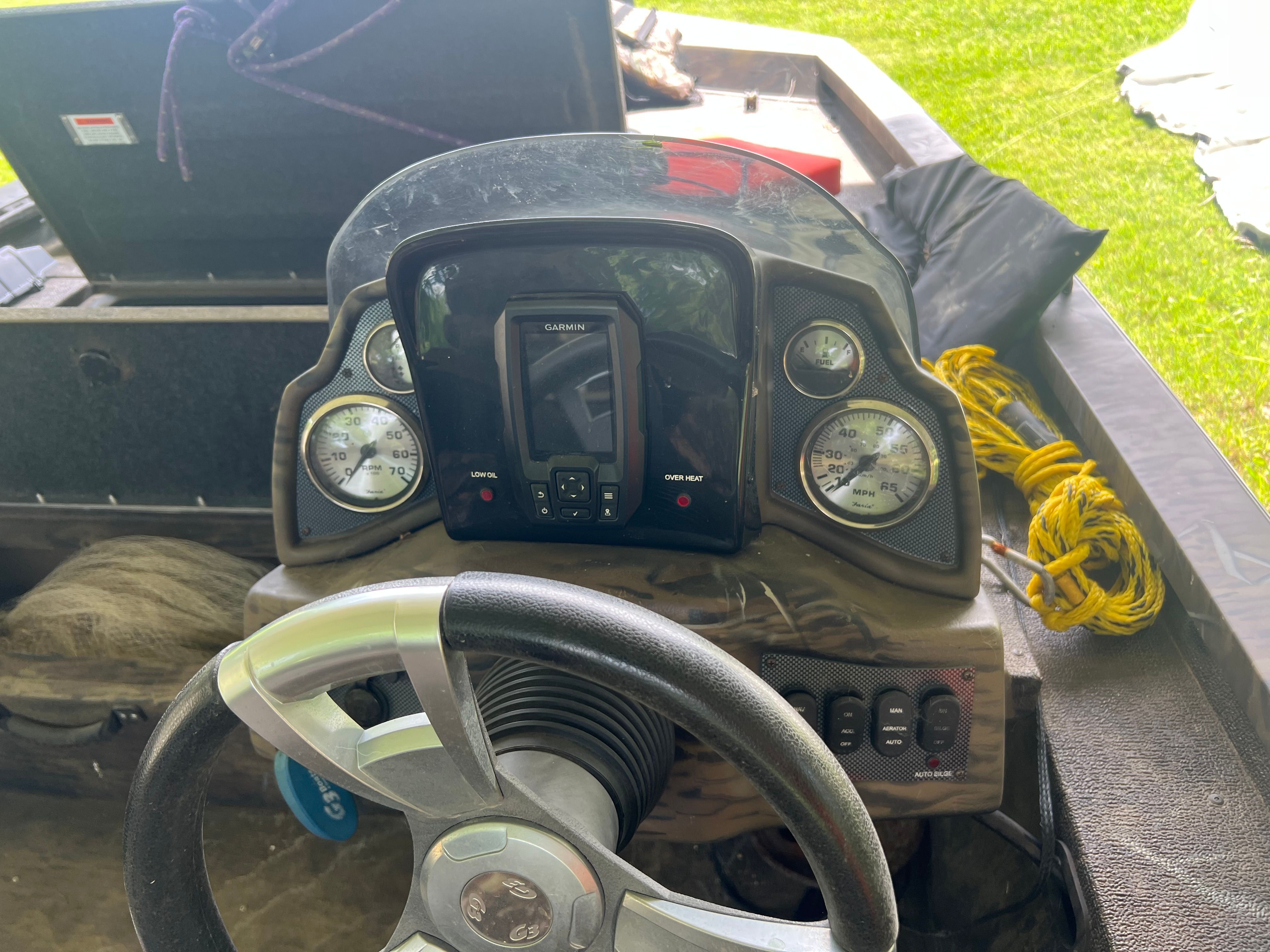 Dashboard of a G3 Sportsman 17 Camo boat with steering wheel and instruments.