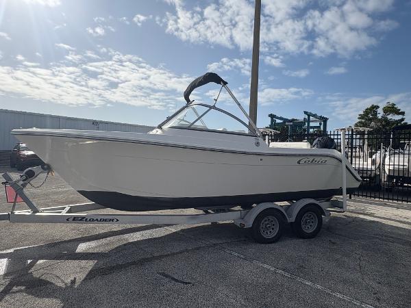 2020 Cobia 220 Dual Console boat on trailer under a partly cloudy sky.
