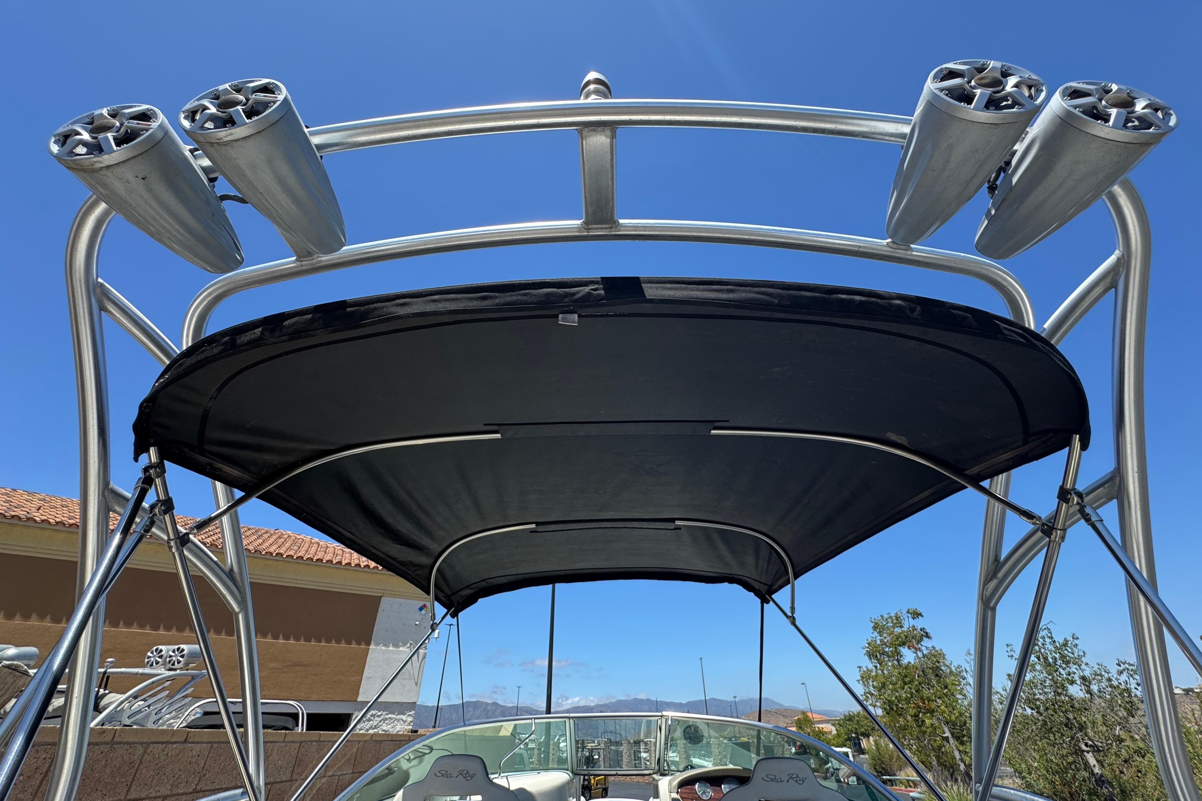 2007 Sea Ray 240 Sundeck with speakers and canopy under clear blue sky.