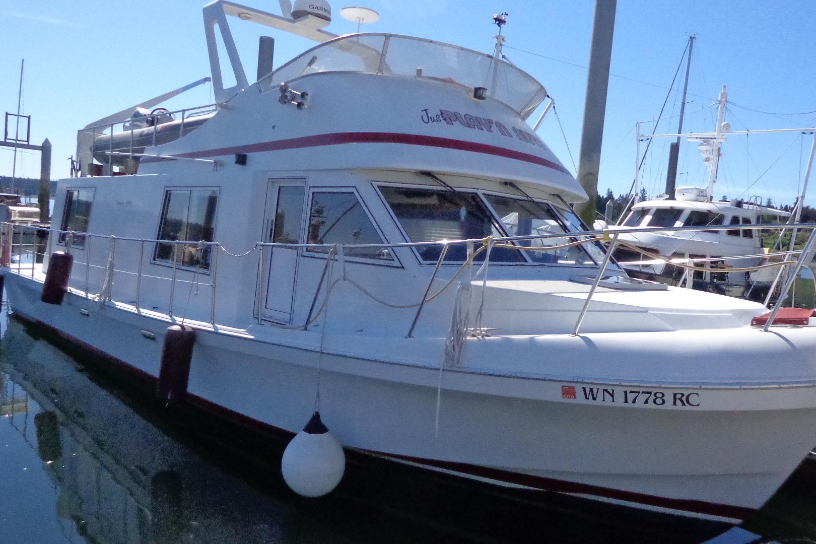 1992 Cruise-A-Home Corsair 4200 boat docked at marina, side view.