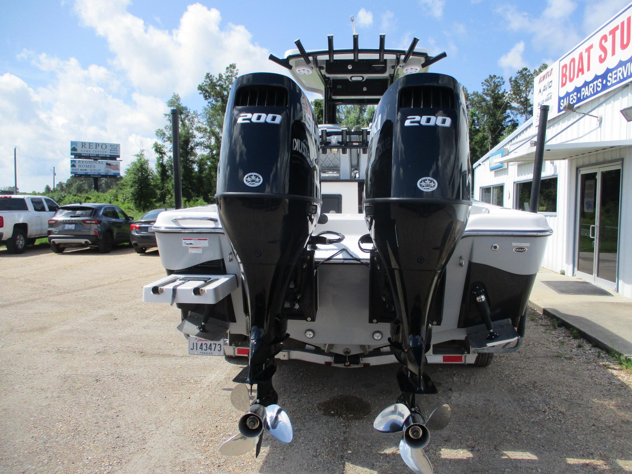 2024 Blue Wave 2800 Makaira boat with dual 200 horsepower engines, parked outside dealership.