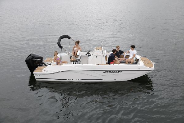 2025 Starcraft SVX 211 OB CC boat with passengers on calm water.