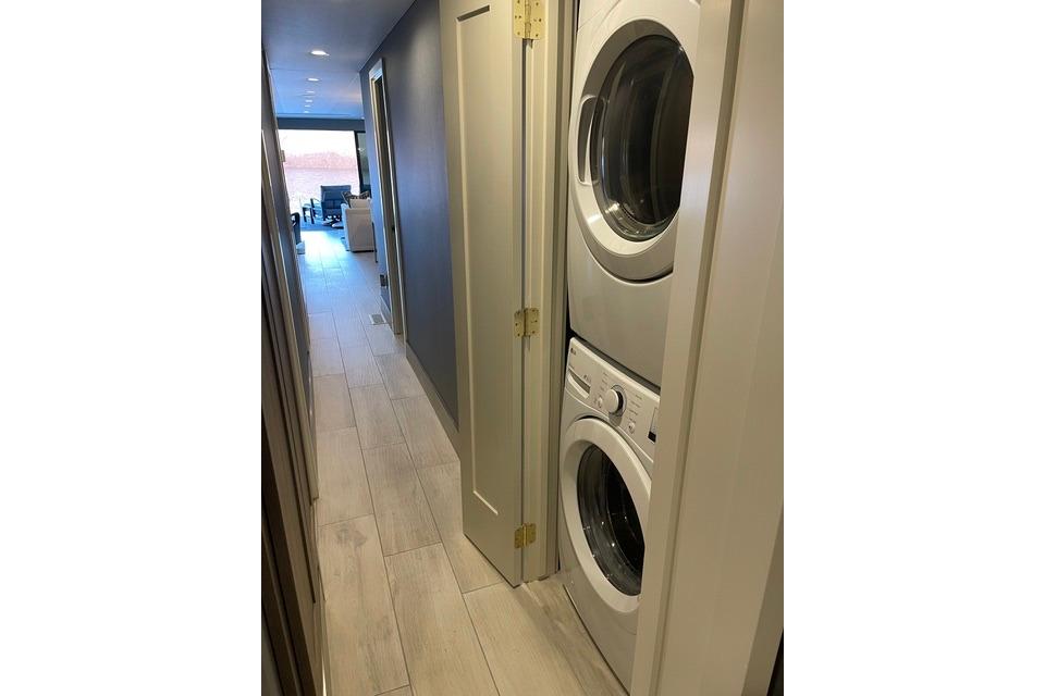 Narrow hallway with stacked washer and dryer, modern interior, Adonia The Queen Elizabeth 2021.