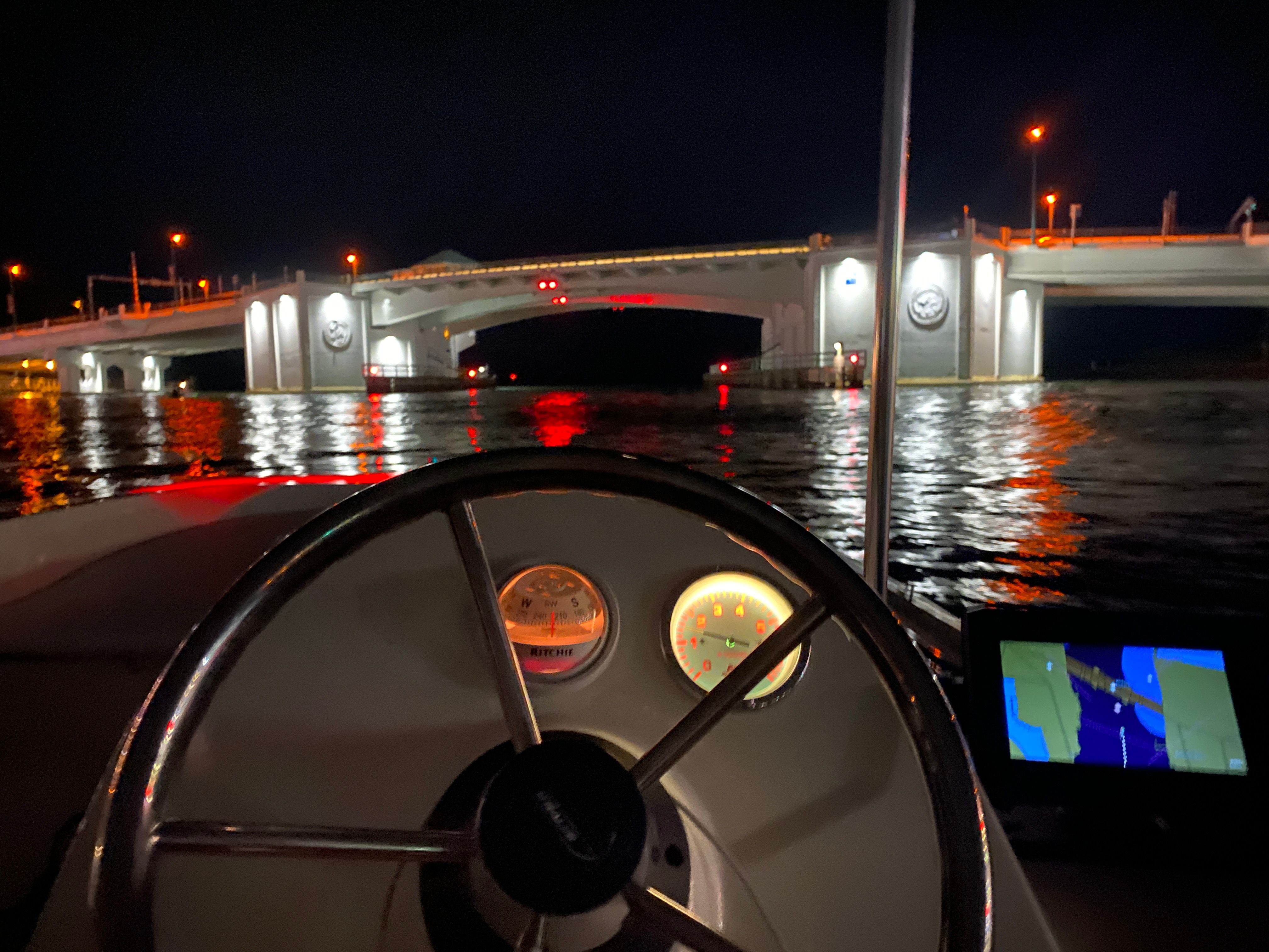 Boston Whaler 150 Super Sport 2018 at night under a lit bridge.