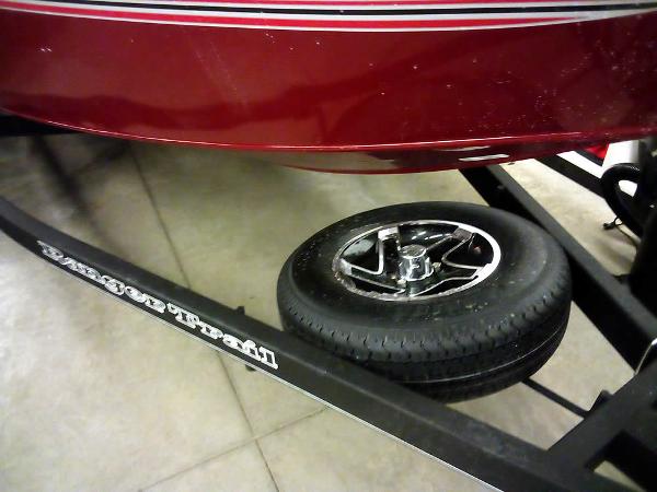 2025 Ranger VS1665 SC boat on trailer with spare tire, red hull, and black frame.