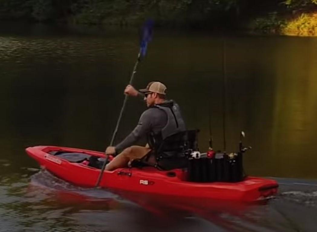 Man paddling a 2023 Bonafide RS117 kayak on a calm lake.
